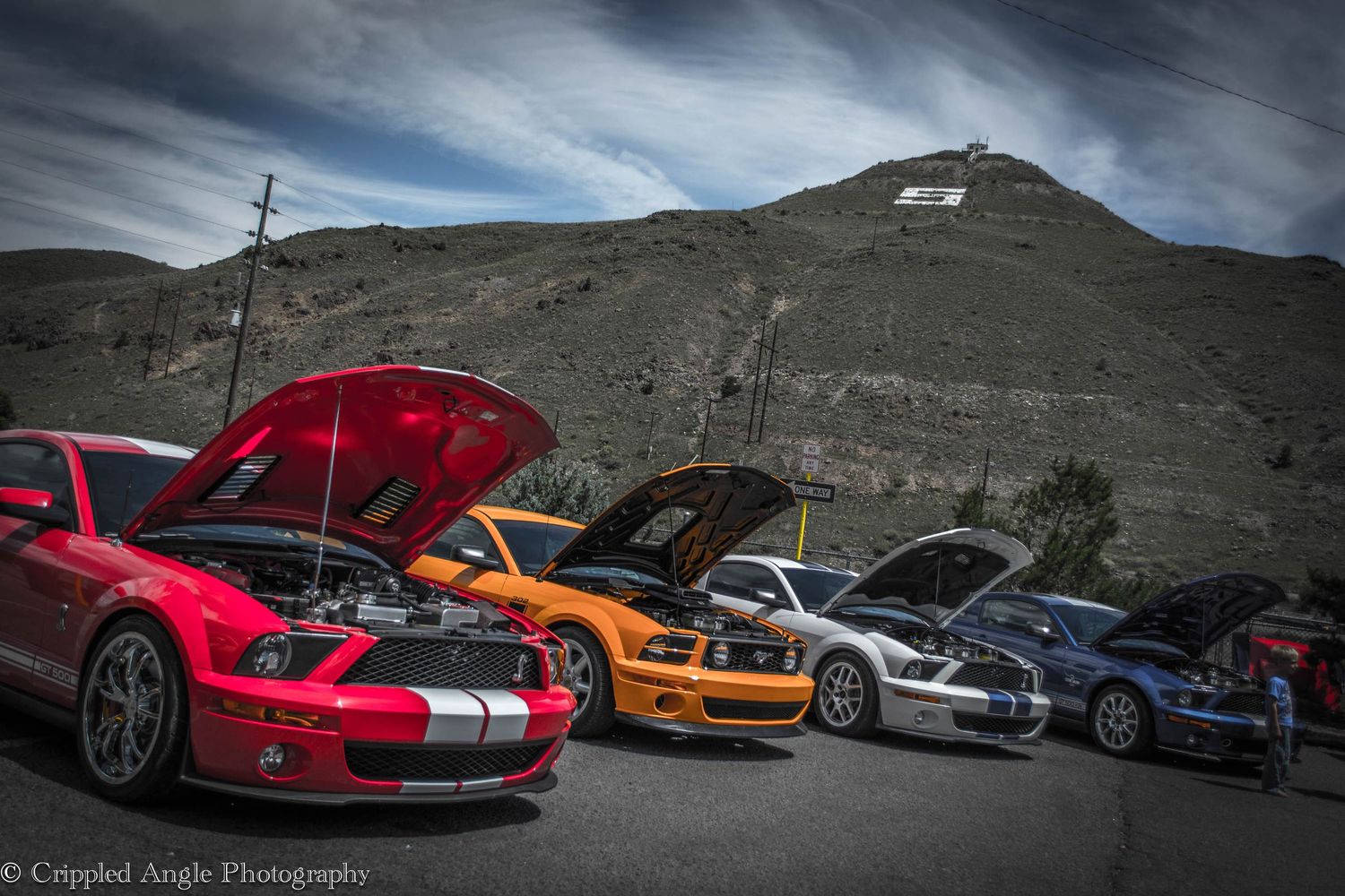 Colorful sports cars lined up against dramatic mountain backdrop.