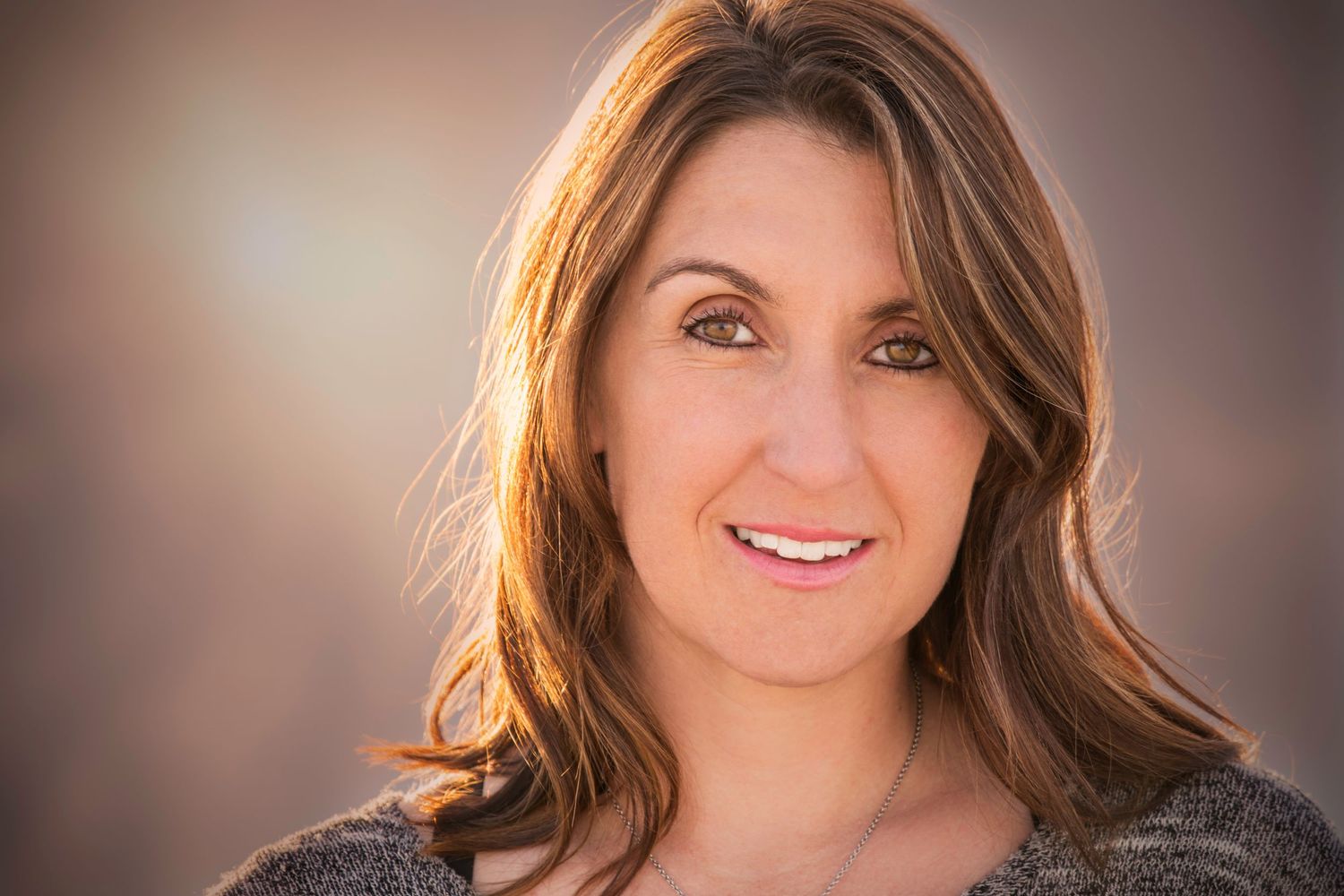 Portrait against a warm background showing a natural, genuine expression.