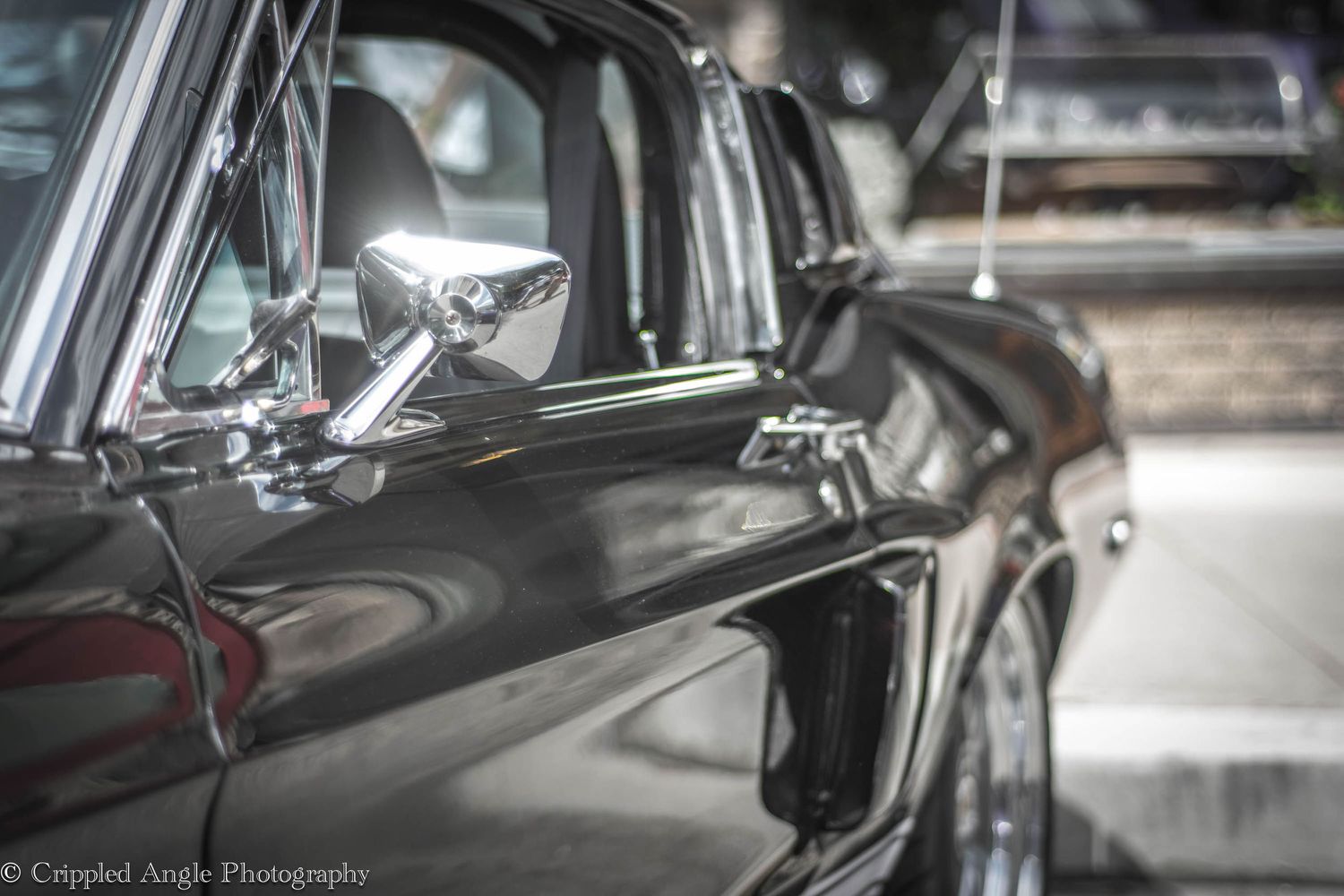 Close up detail shot of classic black car's chrome trim and bodywork.