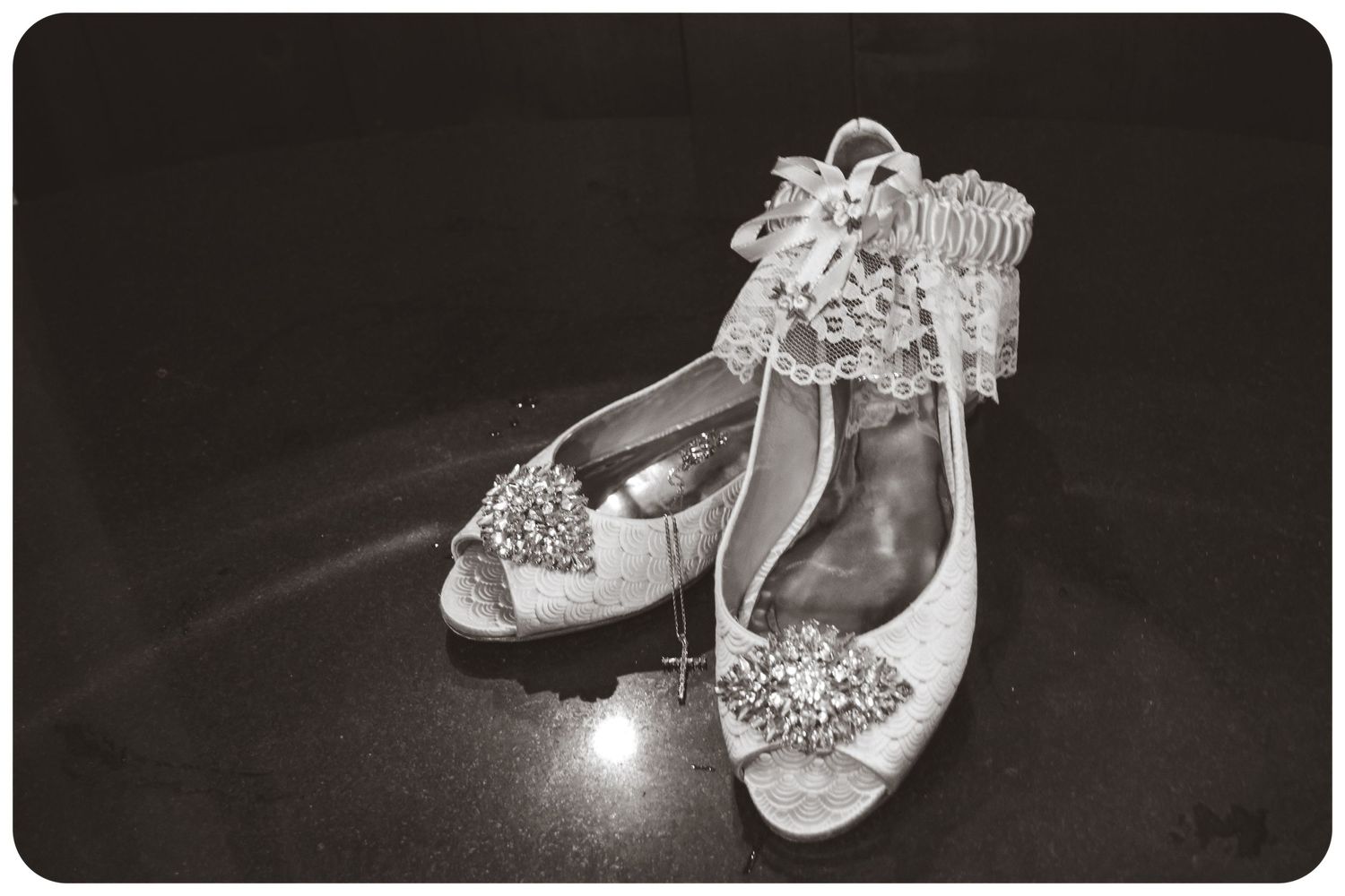 Vintage-style bridal shoes with delicate crystal embellishments photographed in black and white.
