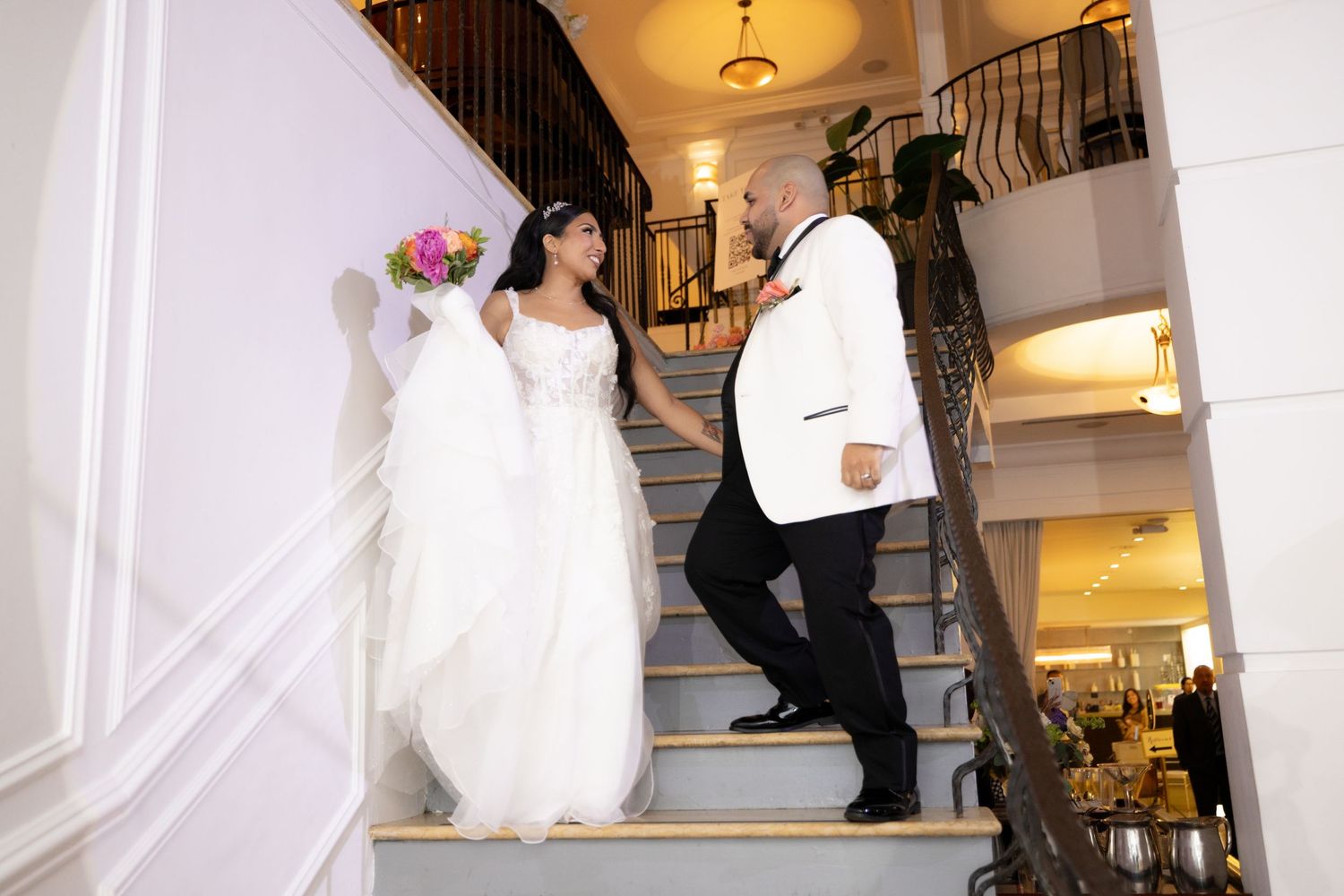 Elegant staircase and interior shots of a wedding venue with white walls and classic architecture.