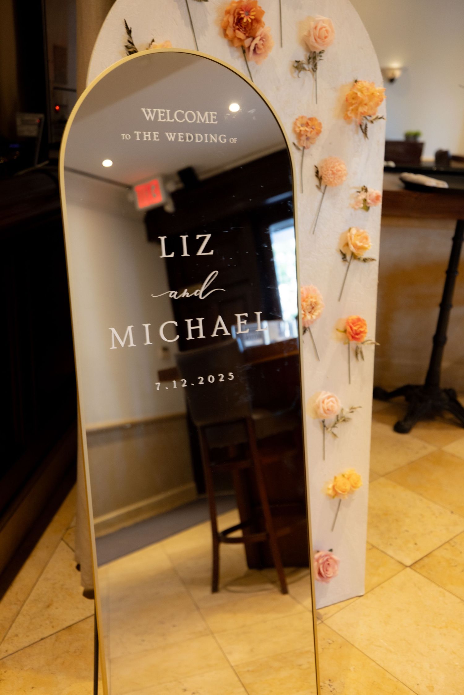 Modern wedding welcome sign with peach floral accents and elegant typography.