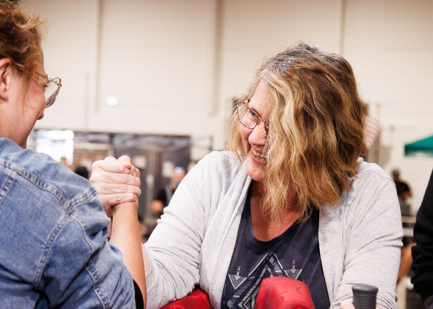 Group of people having animated conversations around a table indoors.