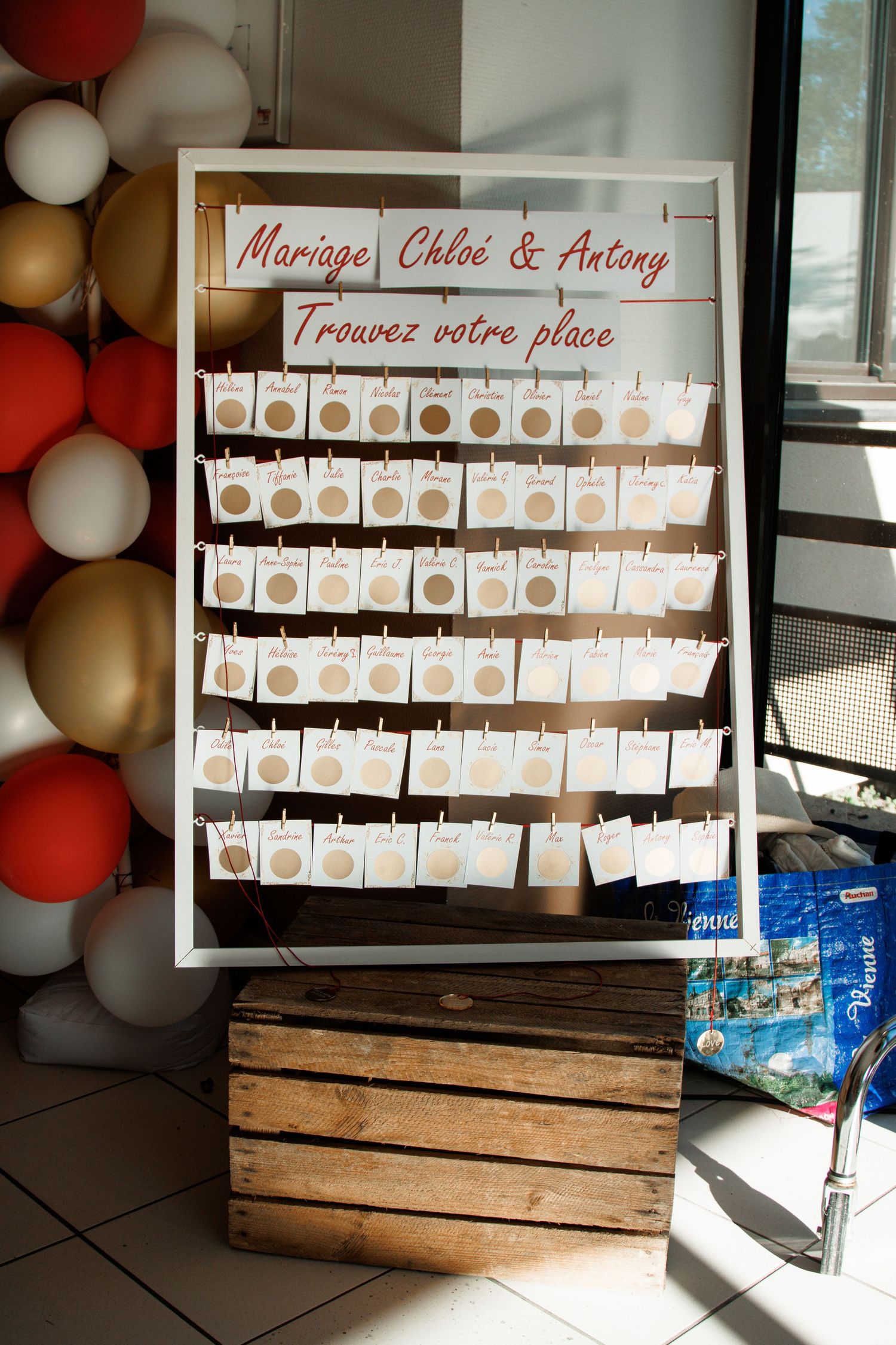 Wedding seating chart board for Mariage Chloé & Antony with white cards and colorful balloons.