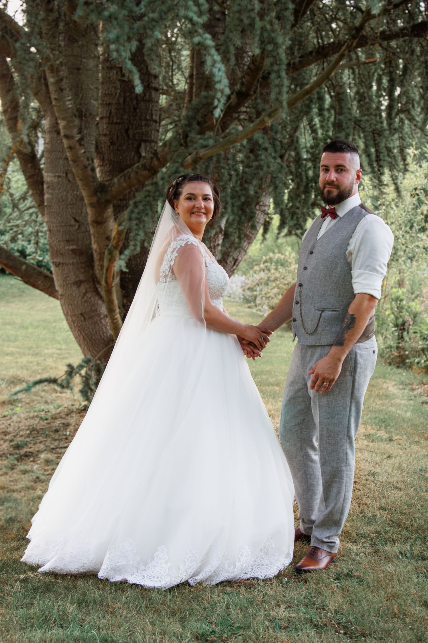 Outdoor wedding portraits featuring a couple in grey and white attire under shady trees.
