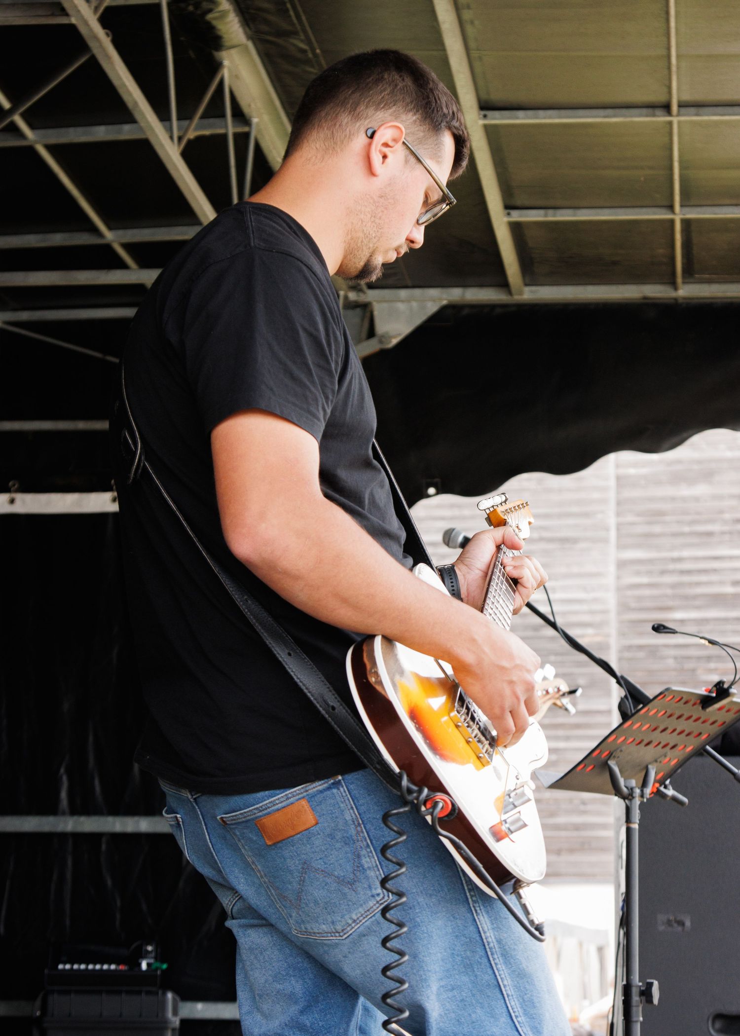 Guitar player performing with electric guitar on stage.