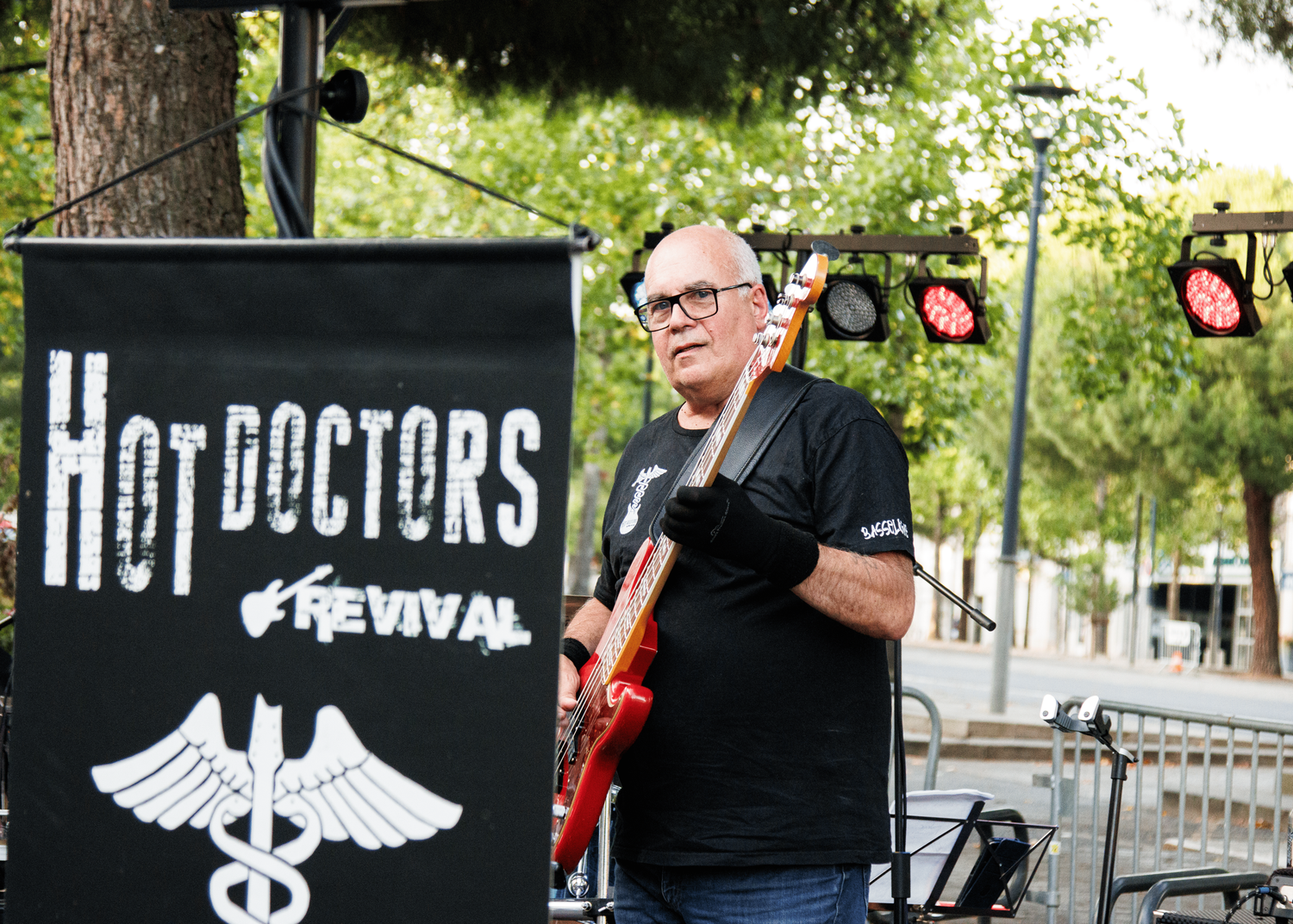 Musician performs near Hot Doctors festival banner at outdoor venue.