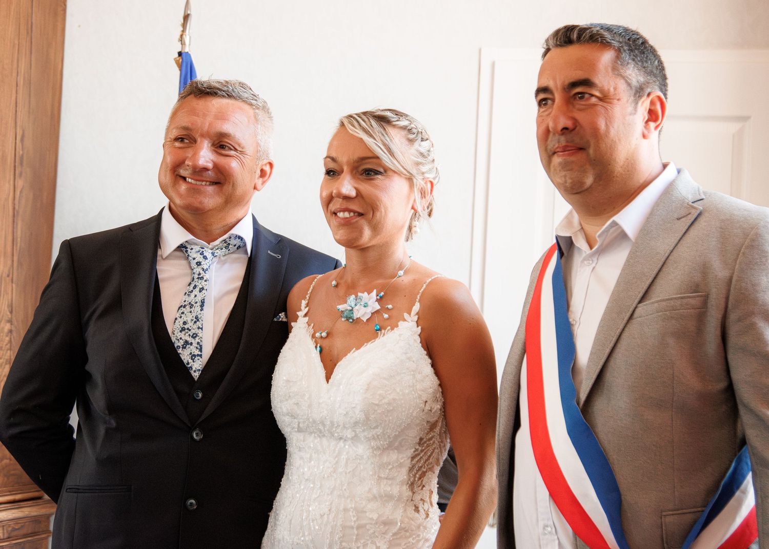 A formal gathering with three people in elegant attire at an official ceremony.