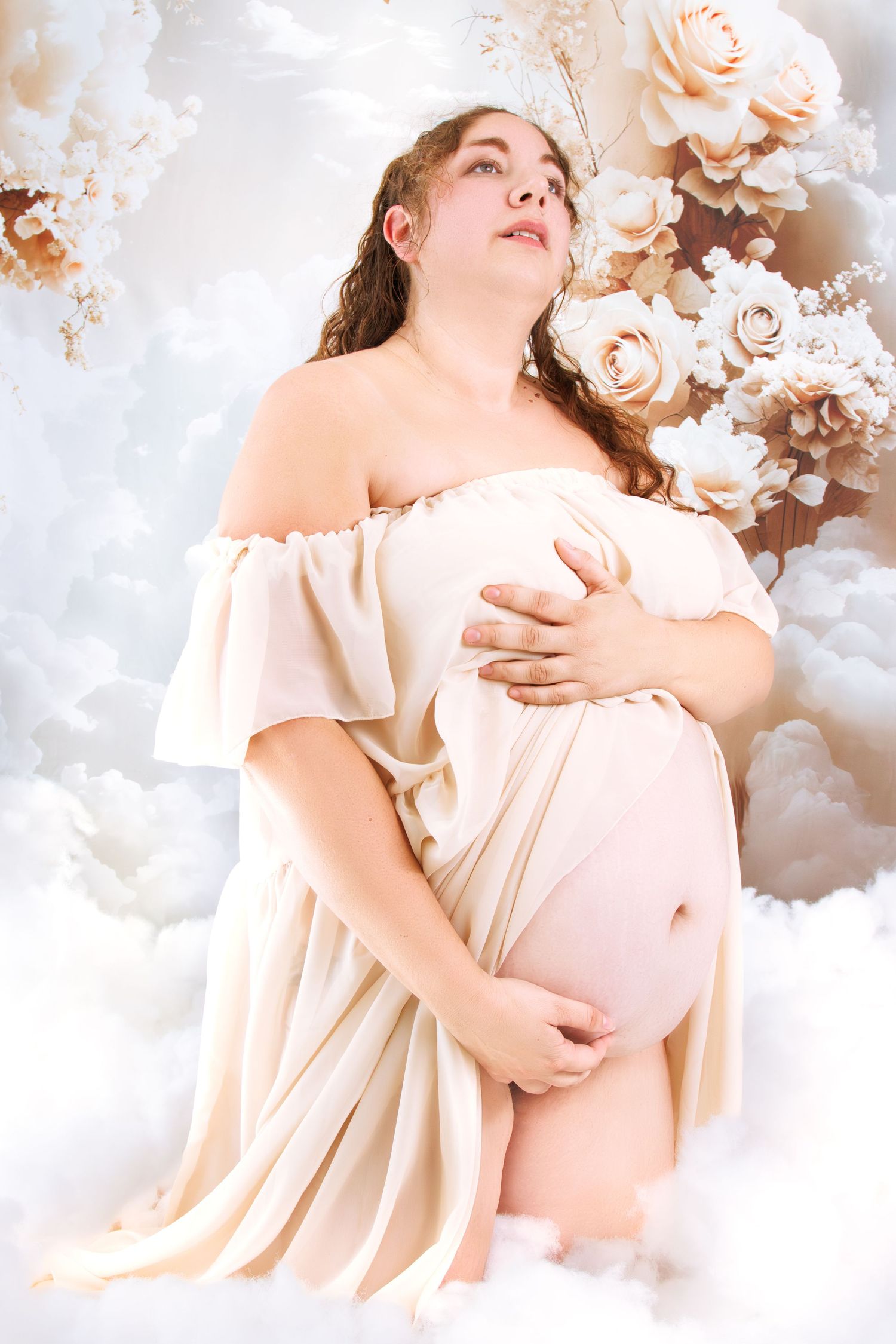Romantic maternity portrait with soft lighting and floral decorations.