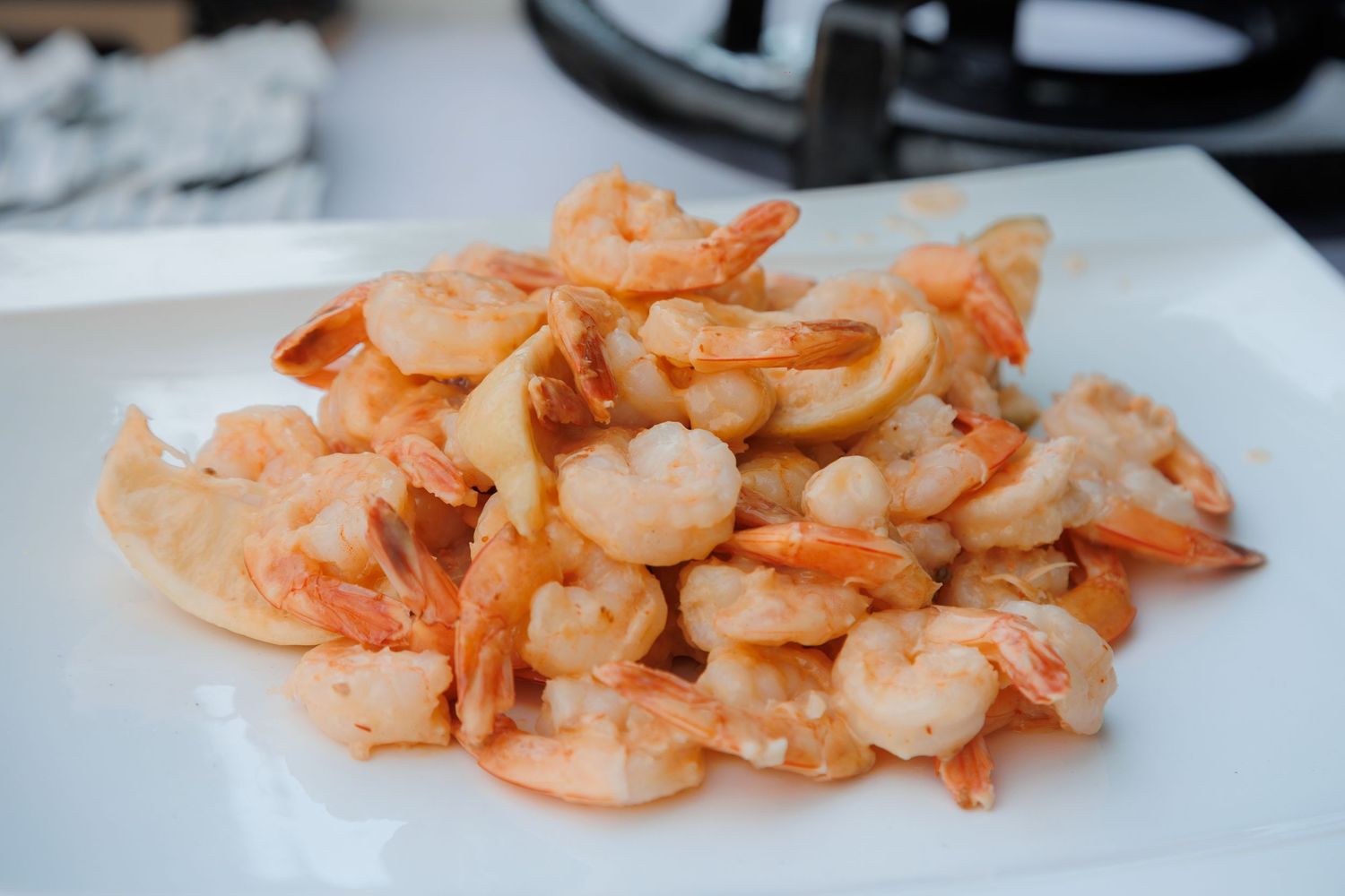 Fresh cooked shrimp piled on white plate served as appetizer at wedding reception catering.