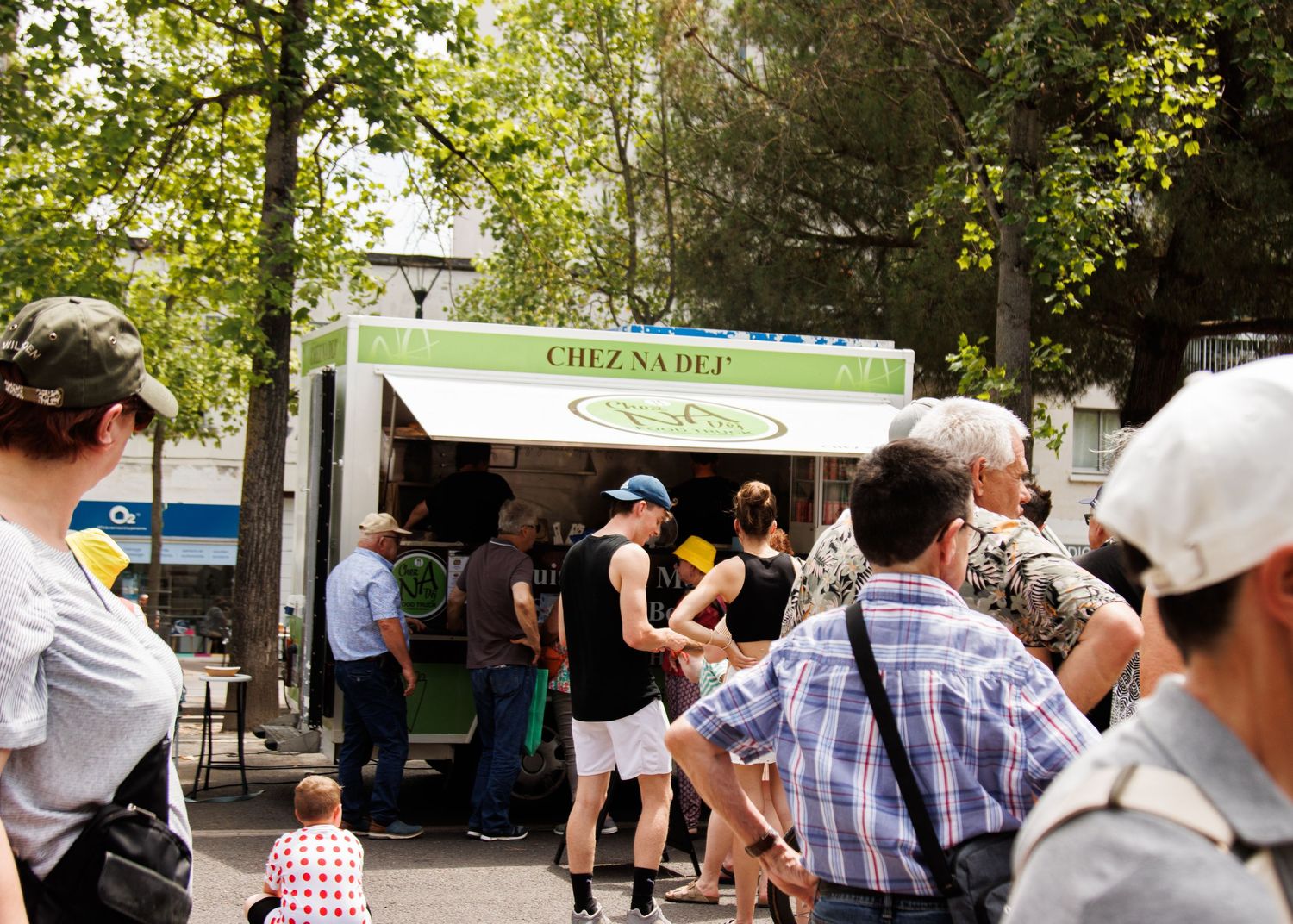 Crowds gathering at an outdoor promotional booth during a summer event.