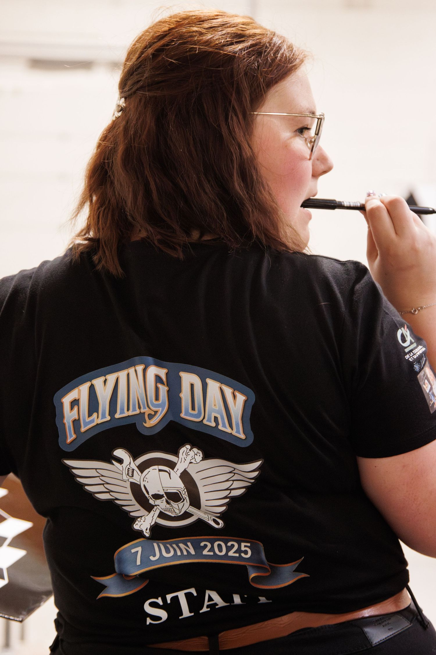 A motorcycle event t-shirt with 'Flying Day' text and winged skull design.