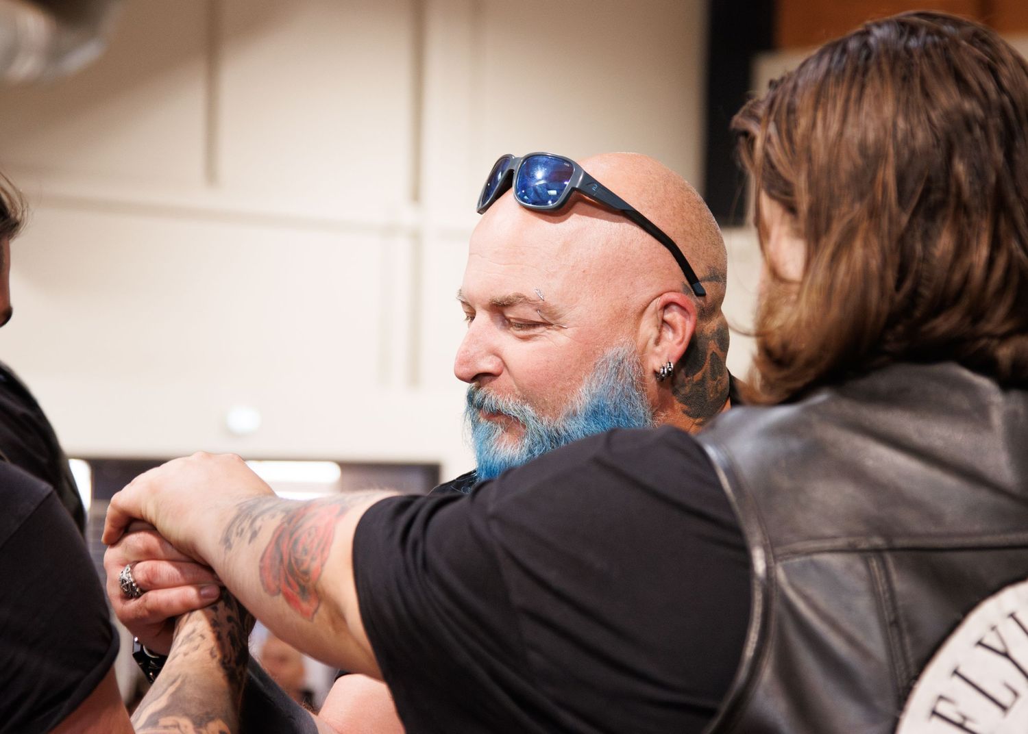 People arm wrestling at an indoor event.