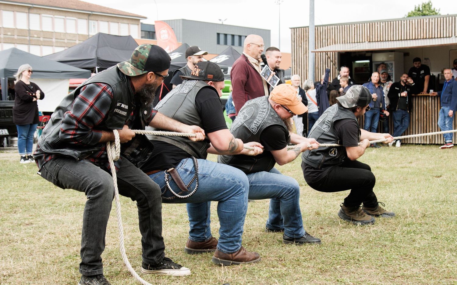 A group of people playing an outdoor game in crouched positions.