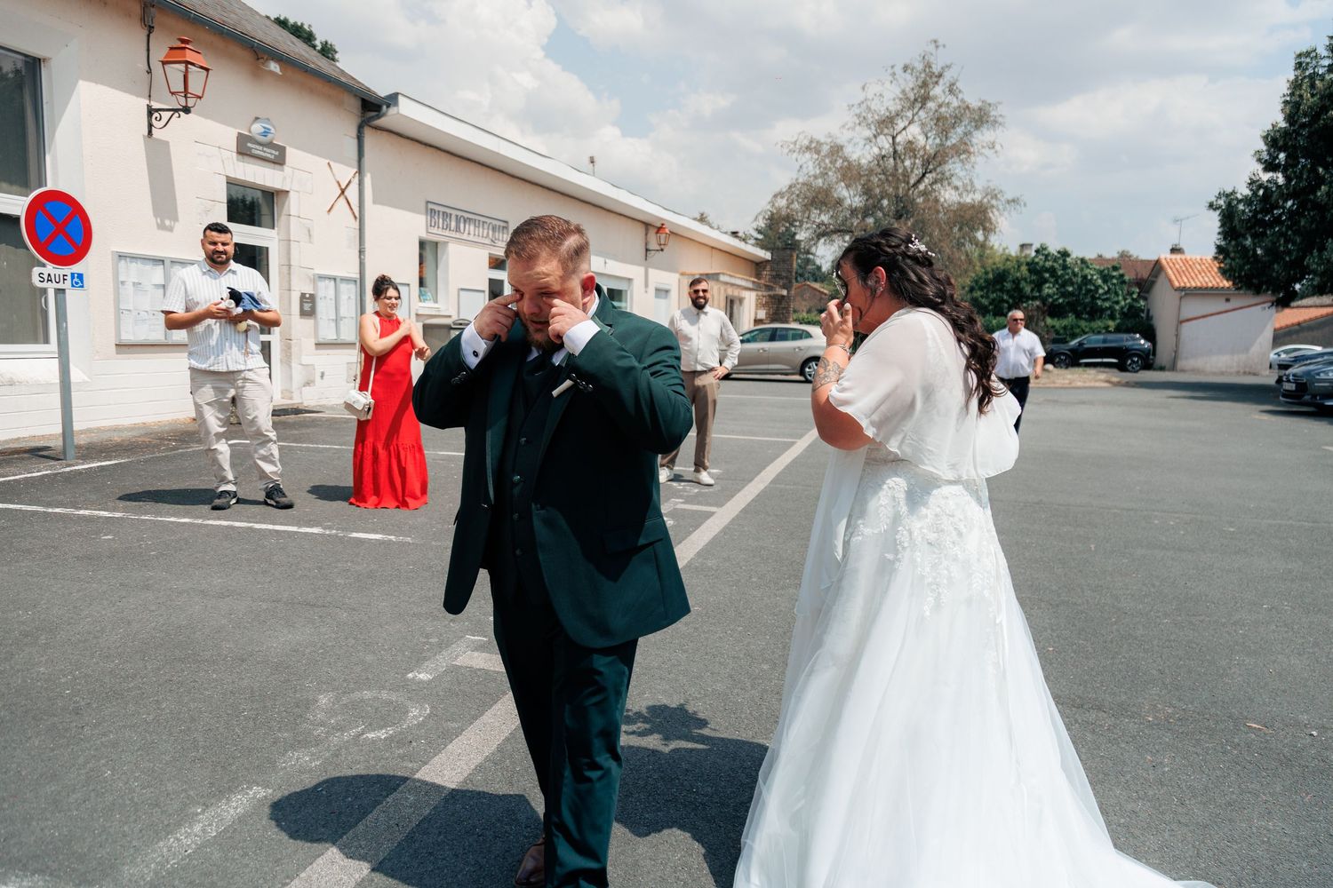 Bride and groom emotional during outdoor wedding ceremony in sunny plaza.
