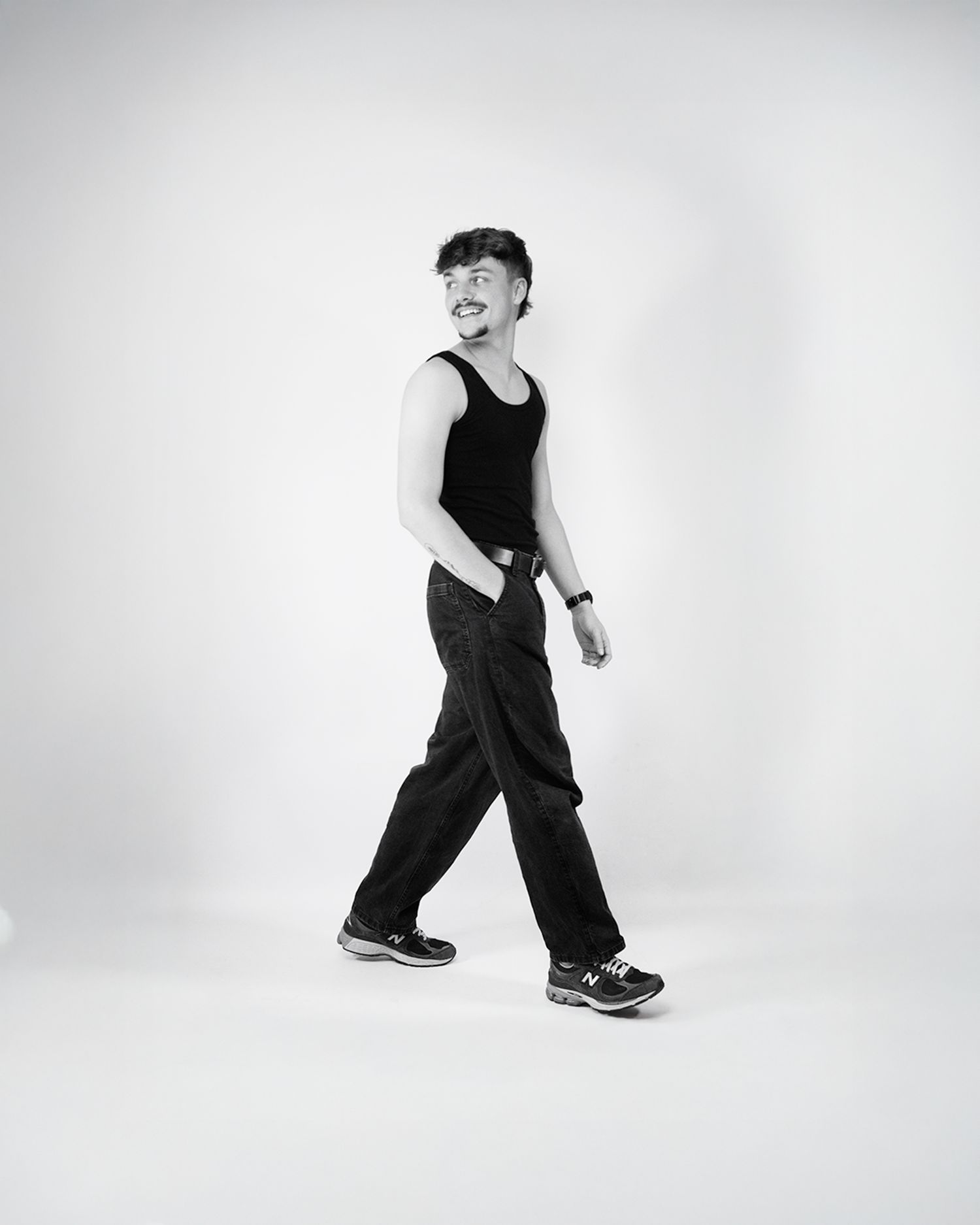 Black and white photo series showing a person in dark clothing performing dance movements against a light background.