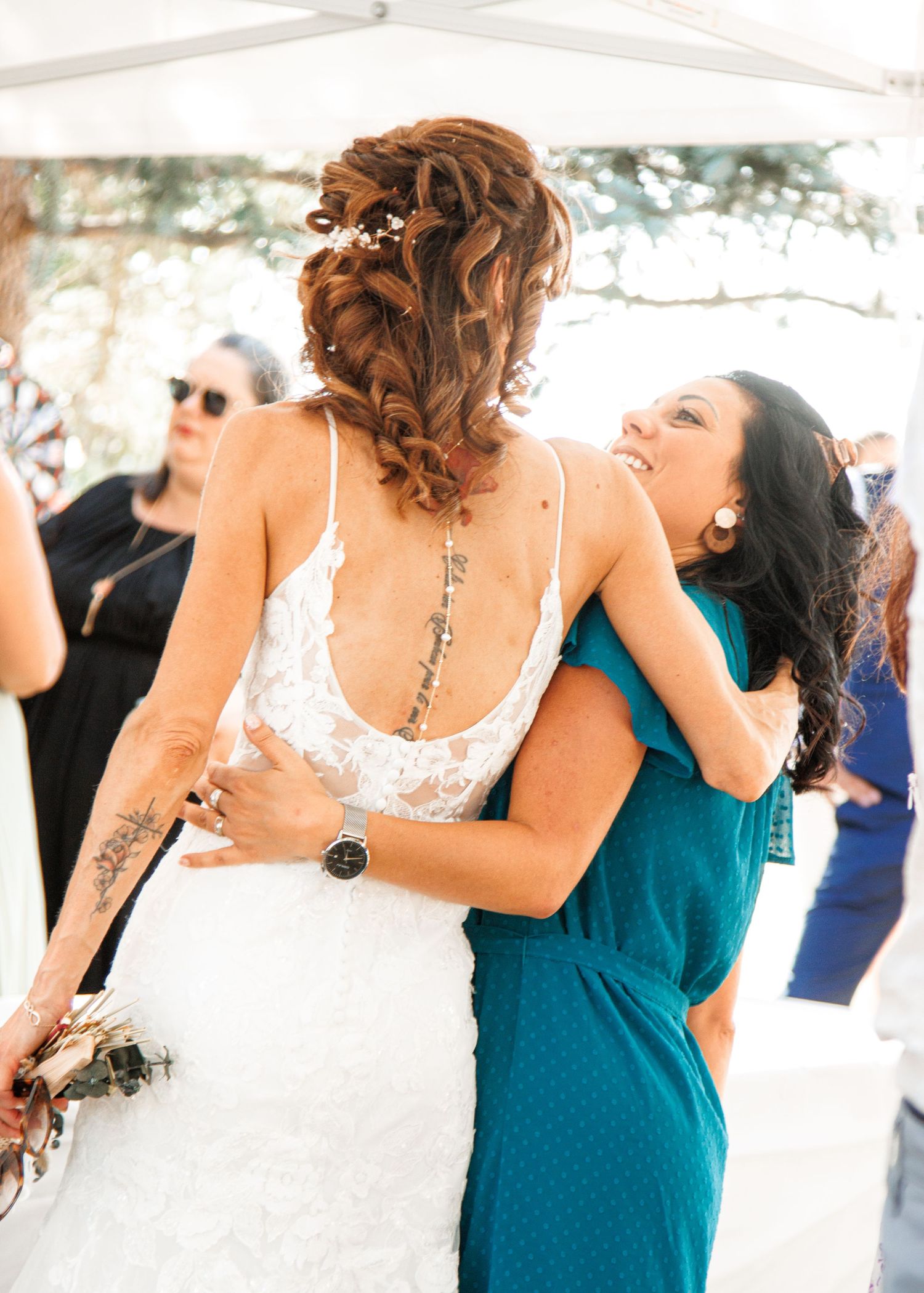Four bridesmaids in turquoise dresses dancing at a wedding reception.