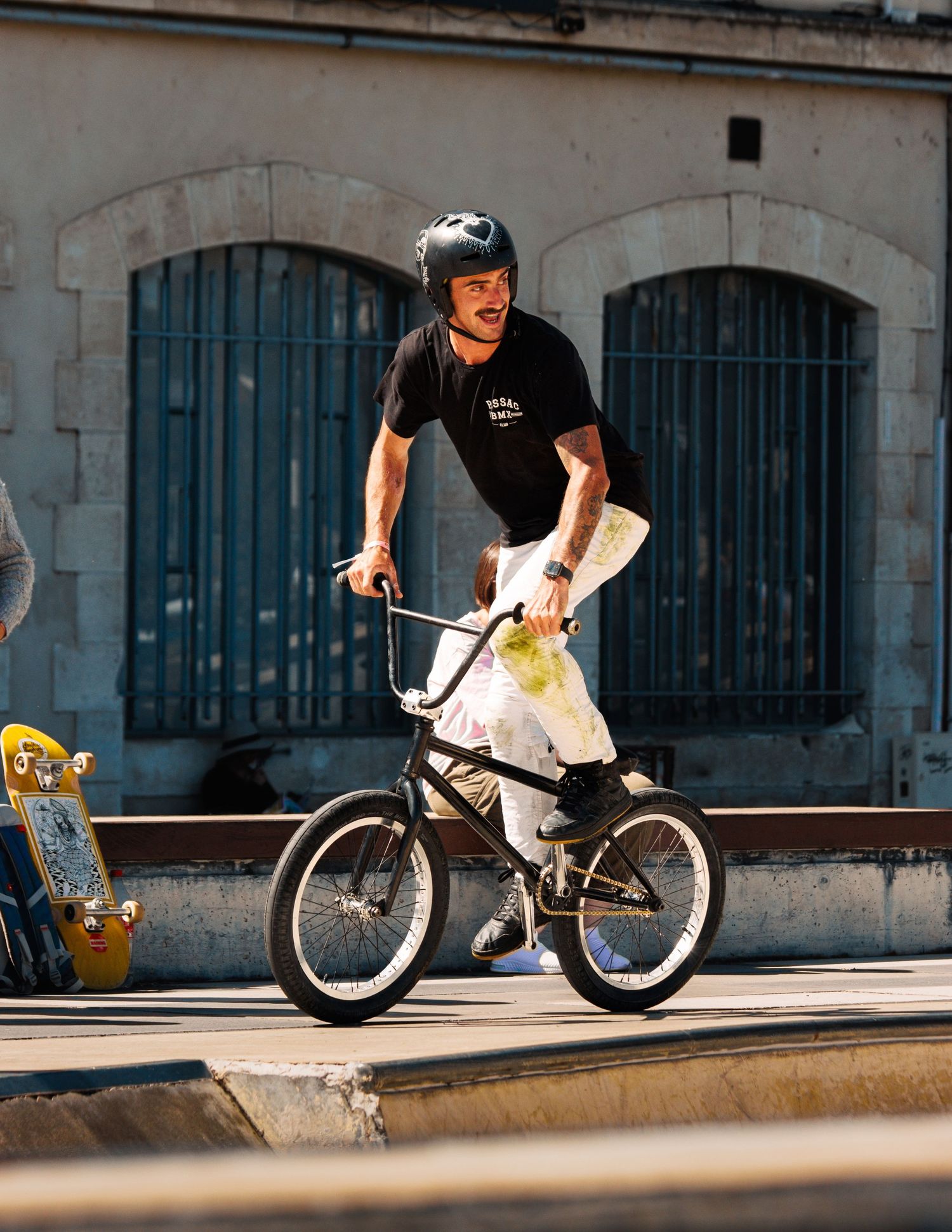 BMX biker executes technical maneuver across urban concrete barriers.