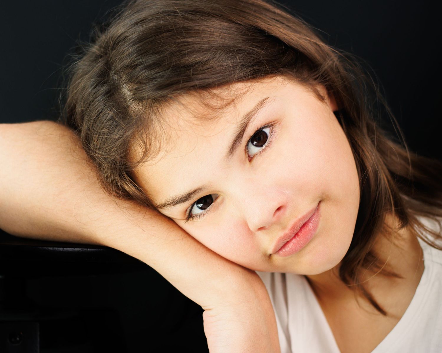 A portrait series showing different angles and expressions of a young woman with dark hair against a dark background.