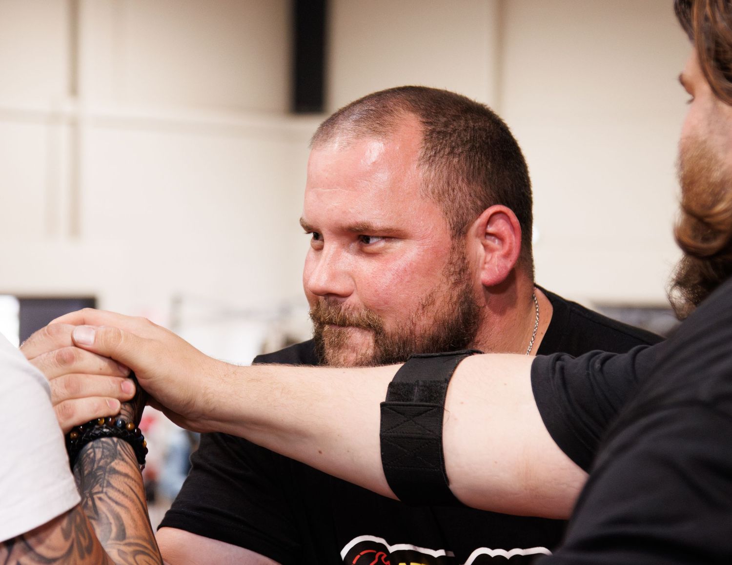 Close up shot of arm wrestling match with competitors gripping hands.