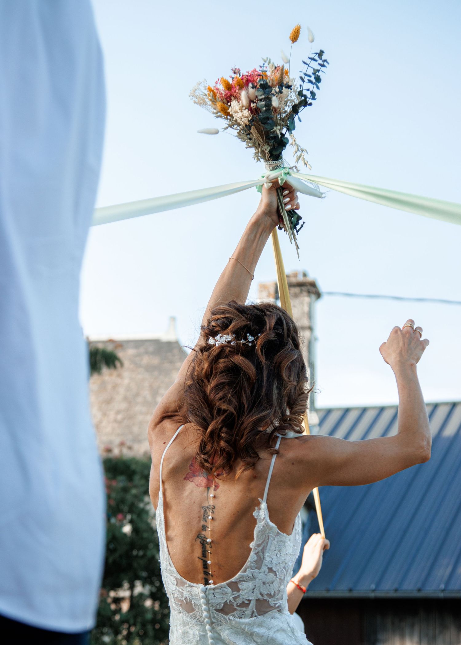 A sequence of candid wedding photos shows the back view of a bride in a lace dress against white curtains.