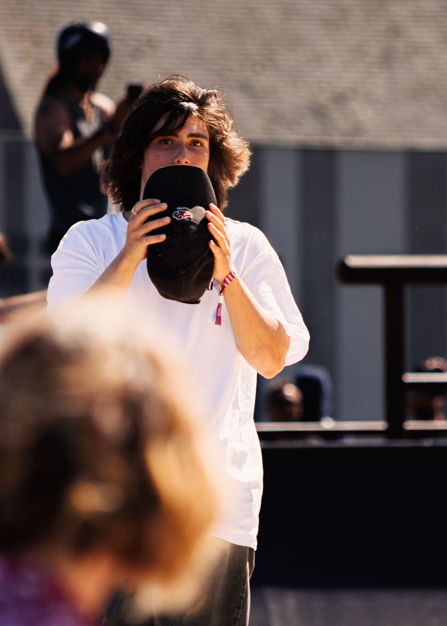 Person with camera capturing skateboarding action at outdoor venue.