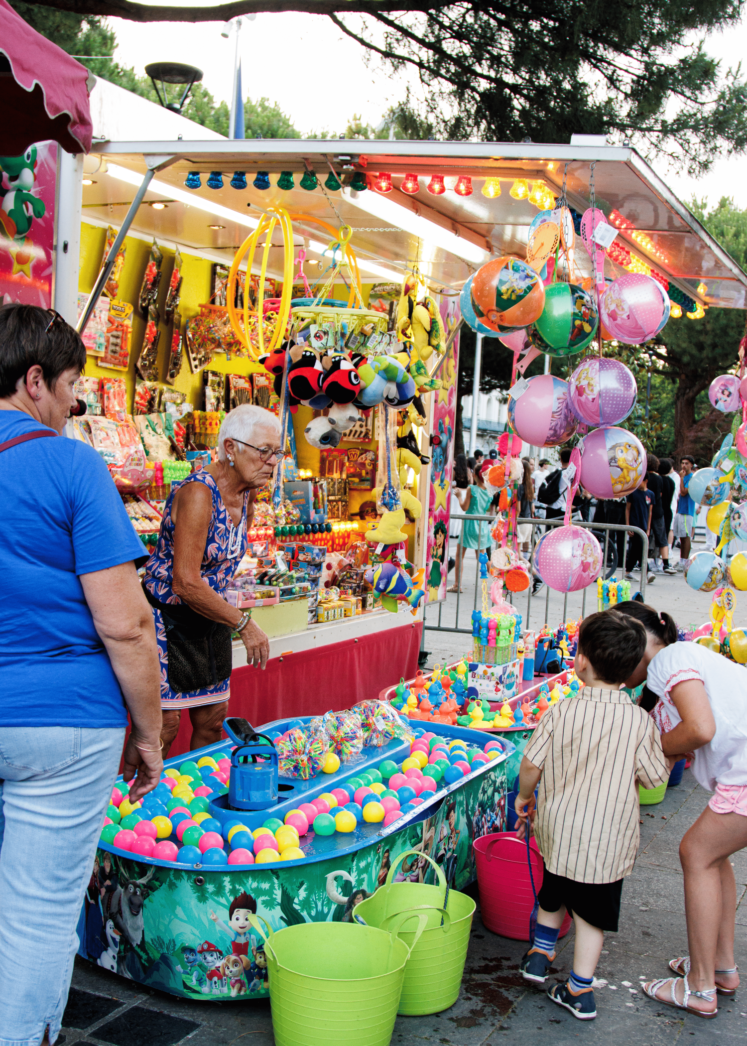 Colorful carnival game booths with stuffed animals and prizes on display.