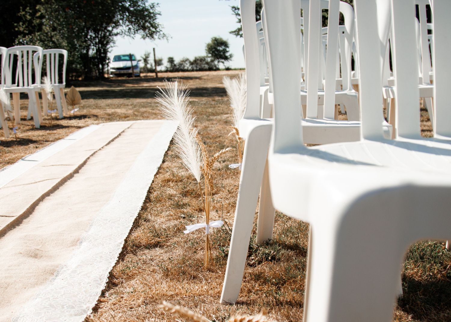 Row of white wooden walkway arches create a geometric pattern in an outdoor garden setting.
