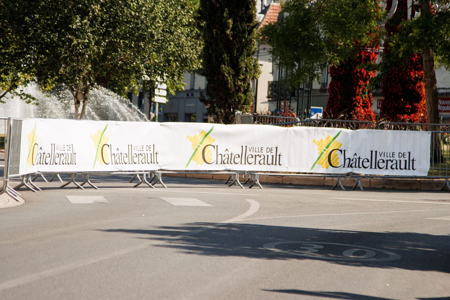 Row of Gstellbrau branded advertising barriers line an empty street during an event.