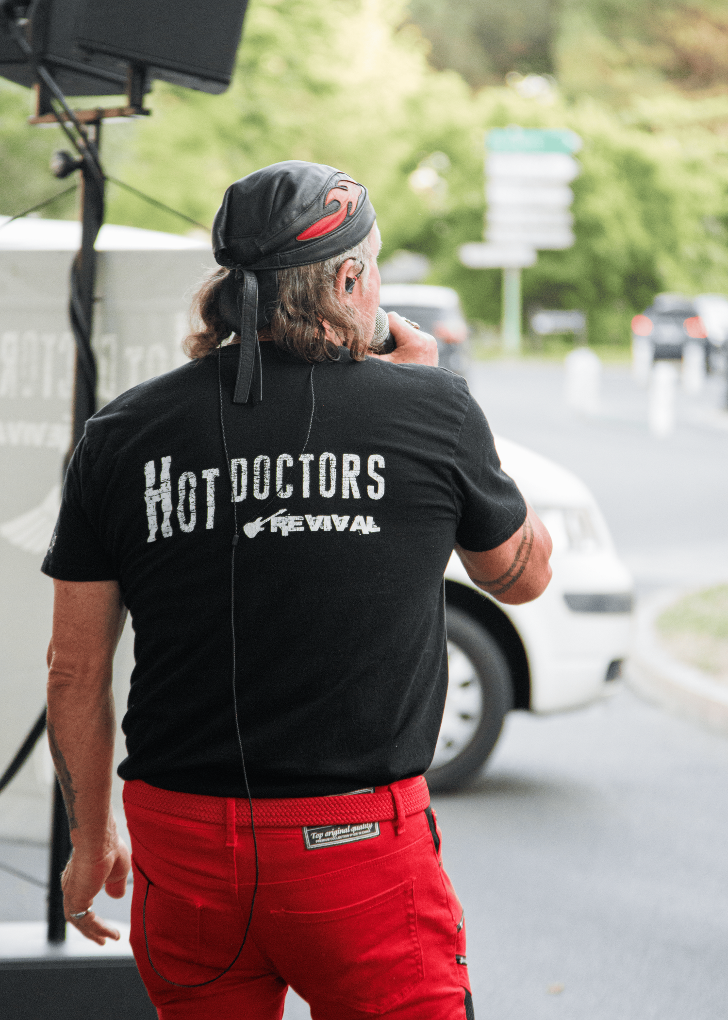 Back view of performer wearing Hot Doctors band t-shirt and red pants.