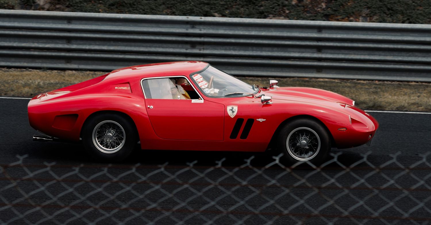 Classic red Ferrari 250 GTO racing on track with iconic fastback design.