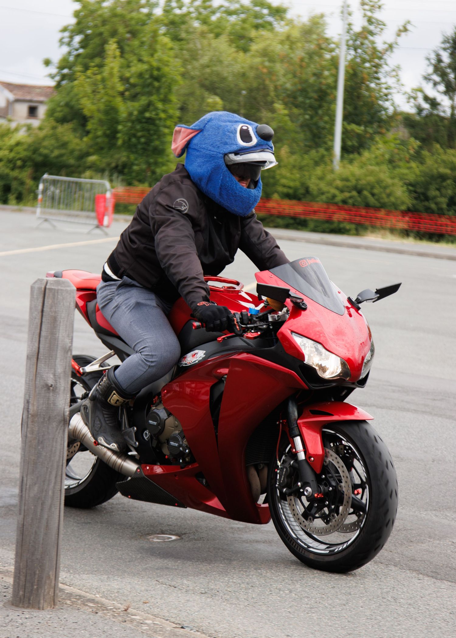 Red sport motorcycles leaning into turns on a practice course with riders in full gear.