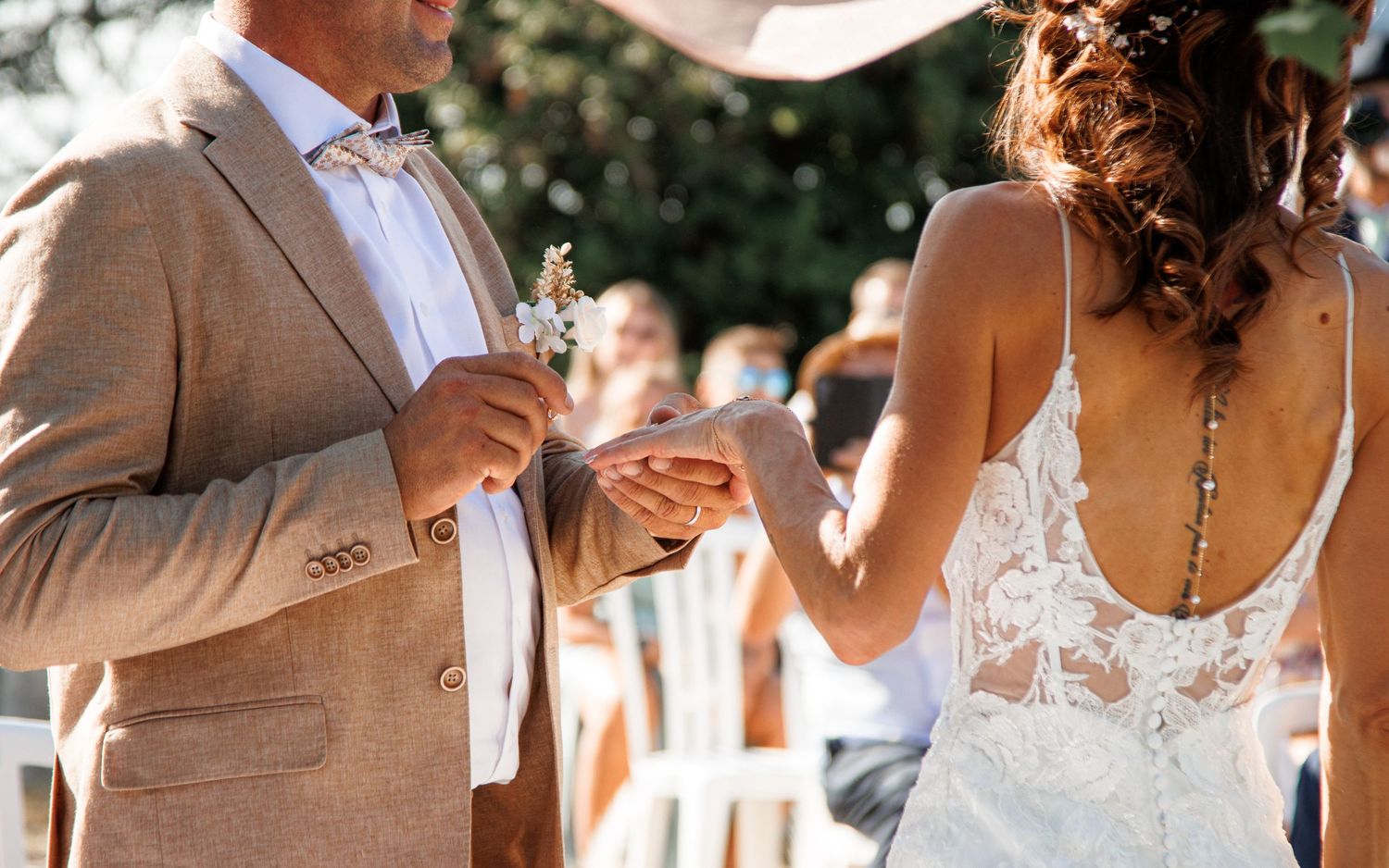 People celebrate at an outdoor wedding ceremony surrounded by natural light and garden scenery.