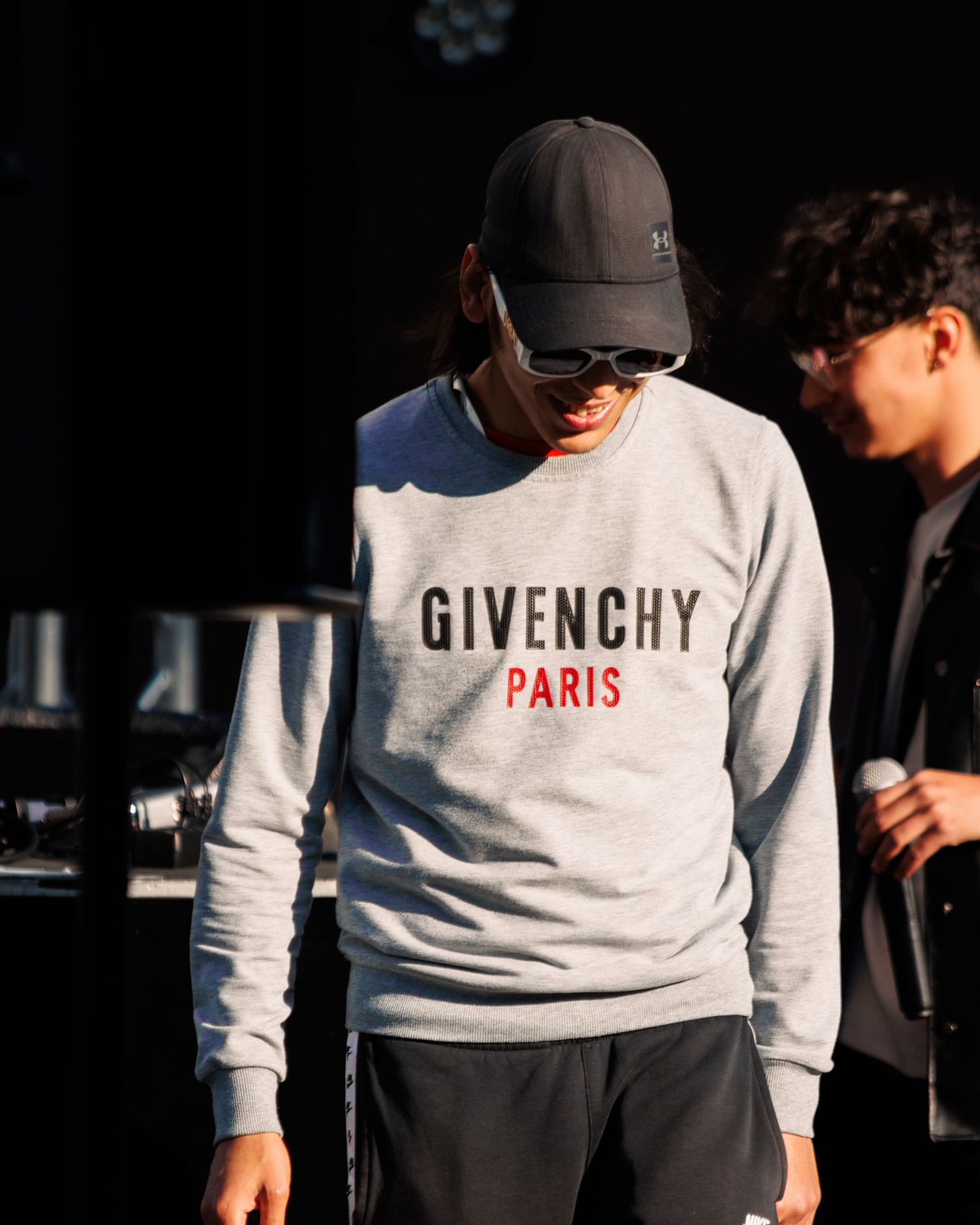 Close-up of white Givenchy Paris logo sweatshirt in contrasting light and shadow.