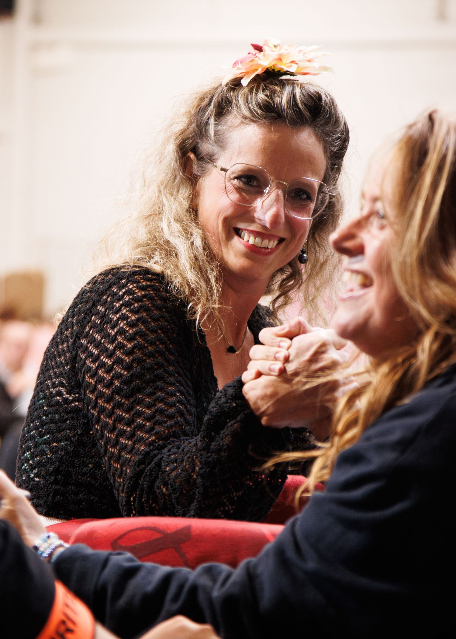 Two women sharing a joyful moment together while sitting indoors.