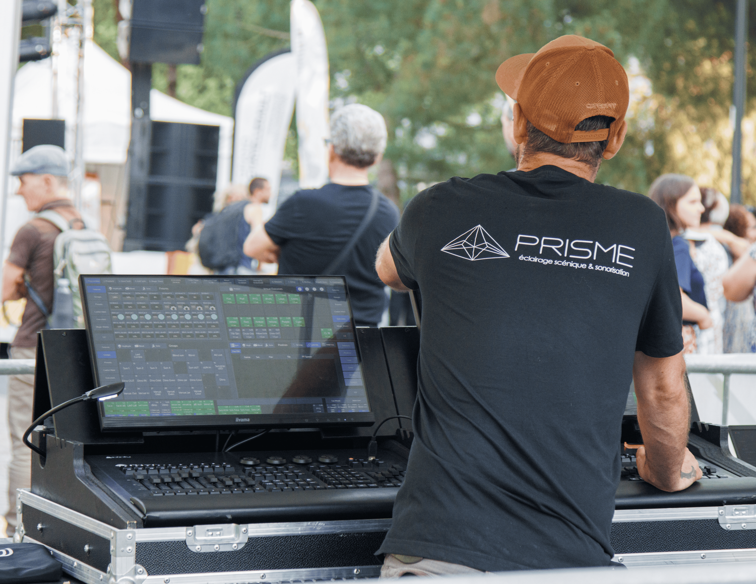 Equipment setup for an outdoor concert with lighting rigs and speakers on stage.