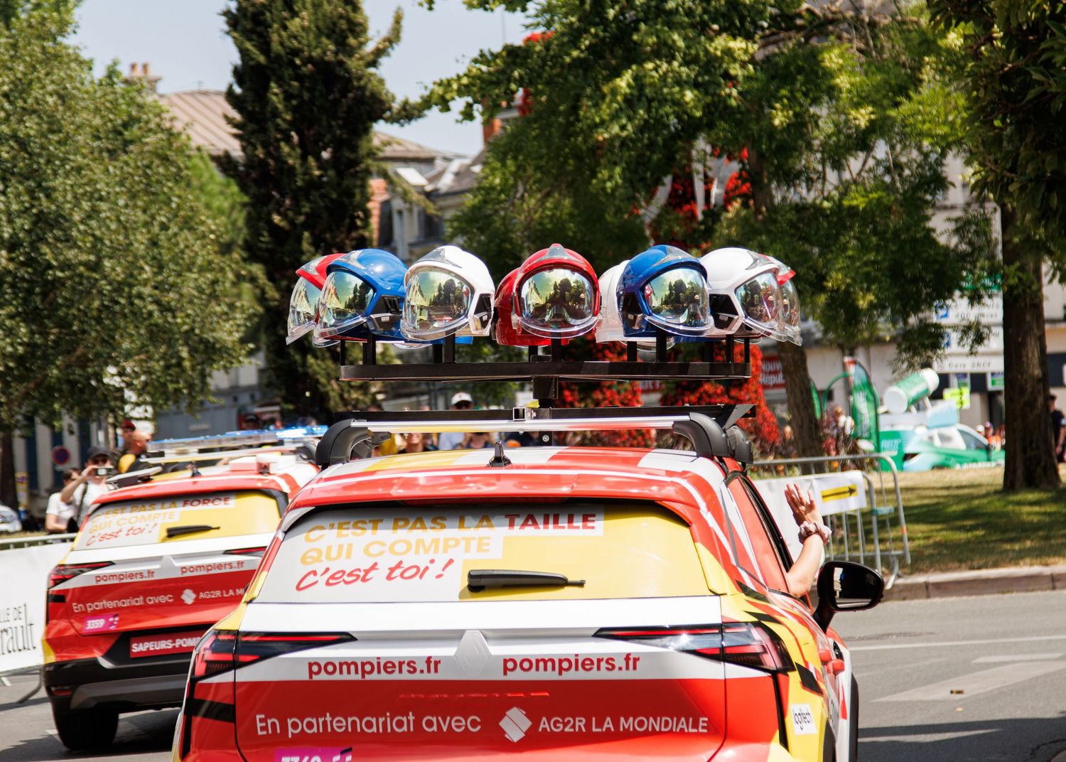 Marketing vehicles with colorful promotional umbrellas parked in a line on a sunny street.