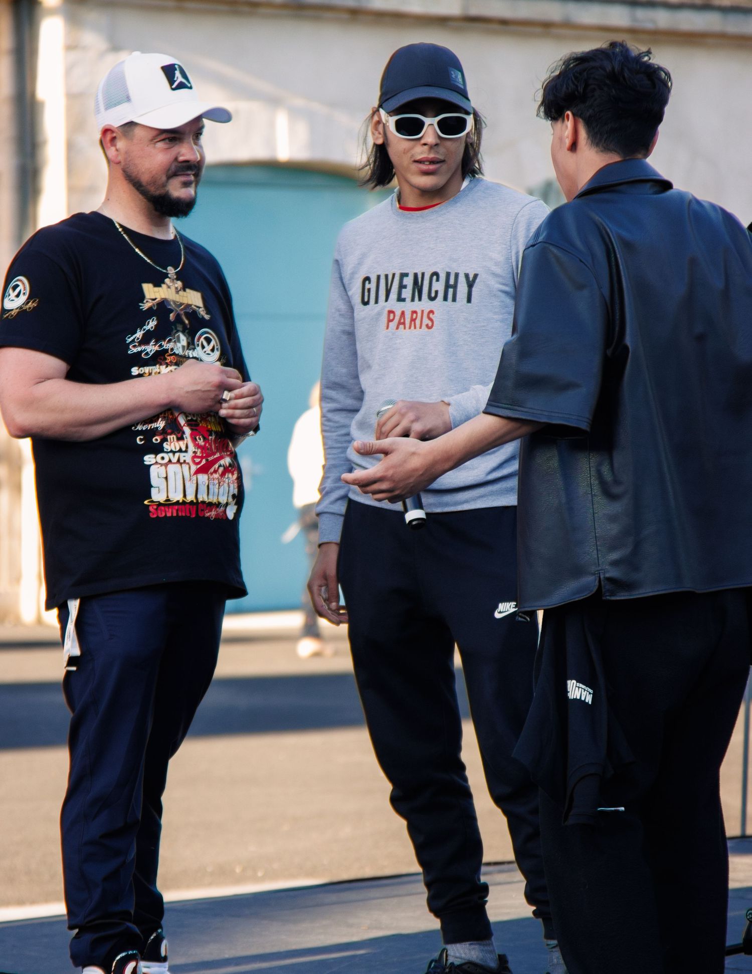 Group of people in casual streetwear having a conversation outdoors.