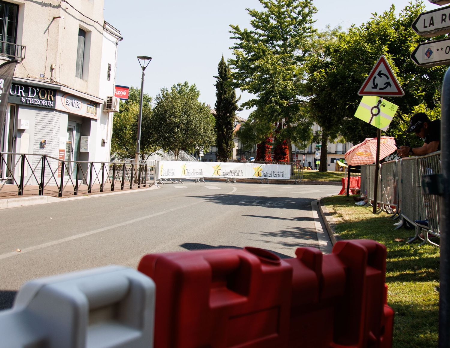 Empty street with safety barriers and event signage visible in an urban setting.