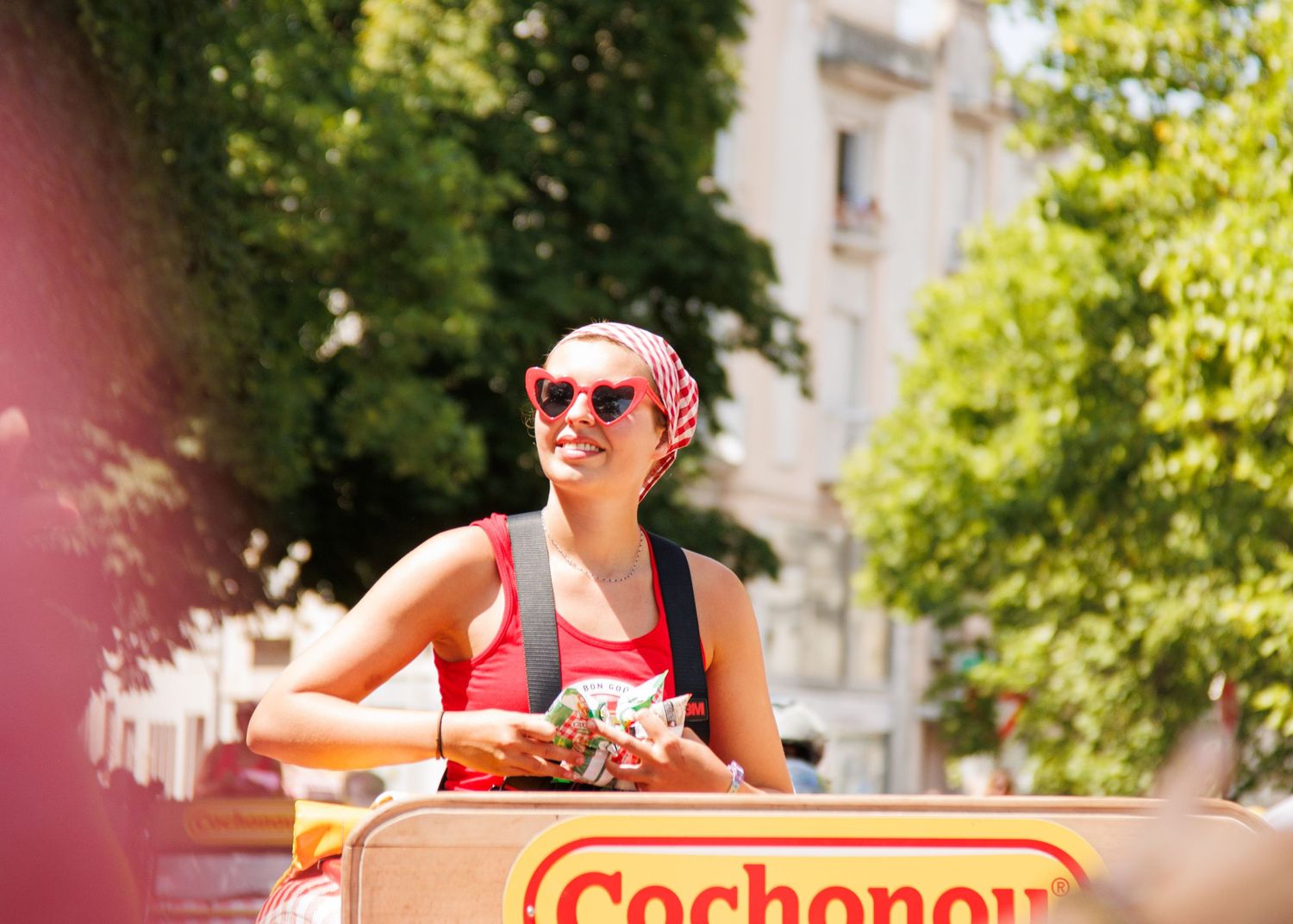 Promotional parade vehicle for Cochonou brand rolls through a summer street celebration.