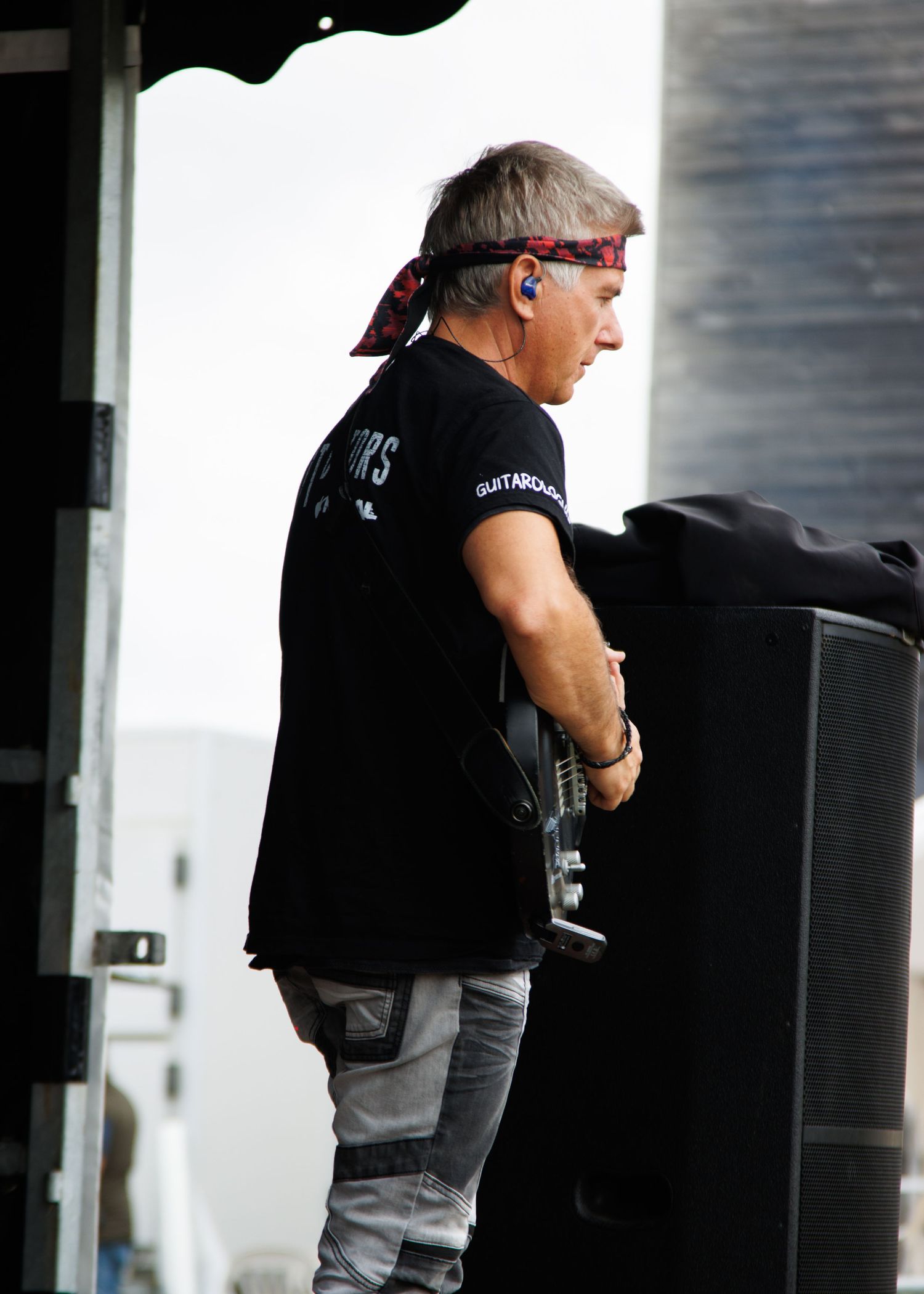 Stage performer wearing sunglasses and headset while performing at outdoor venue.