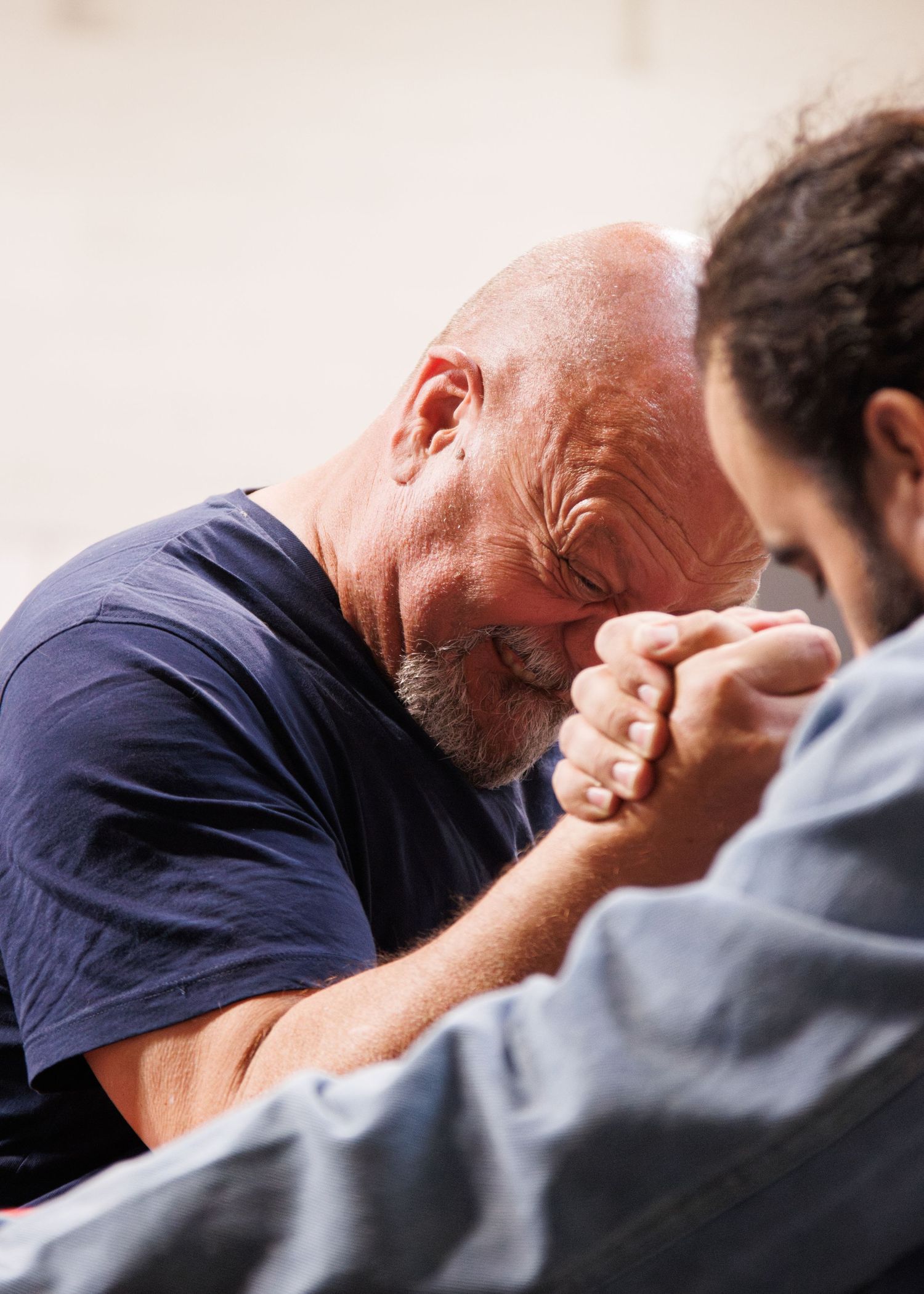 Competitive arm wrestling match shows intense concentration between opponents.