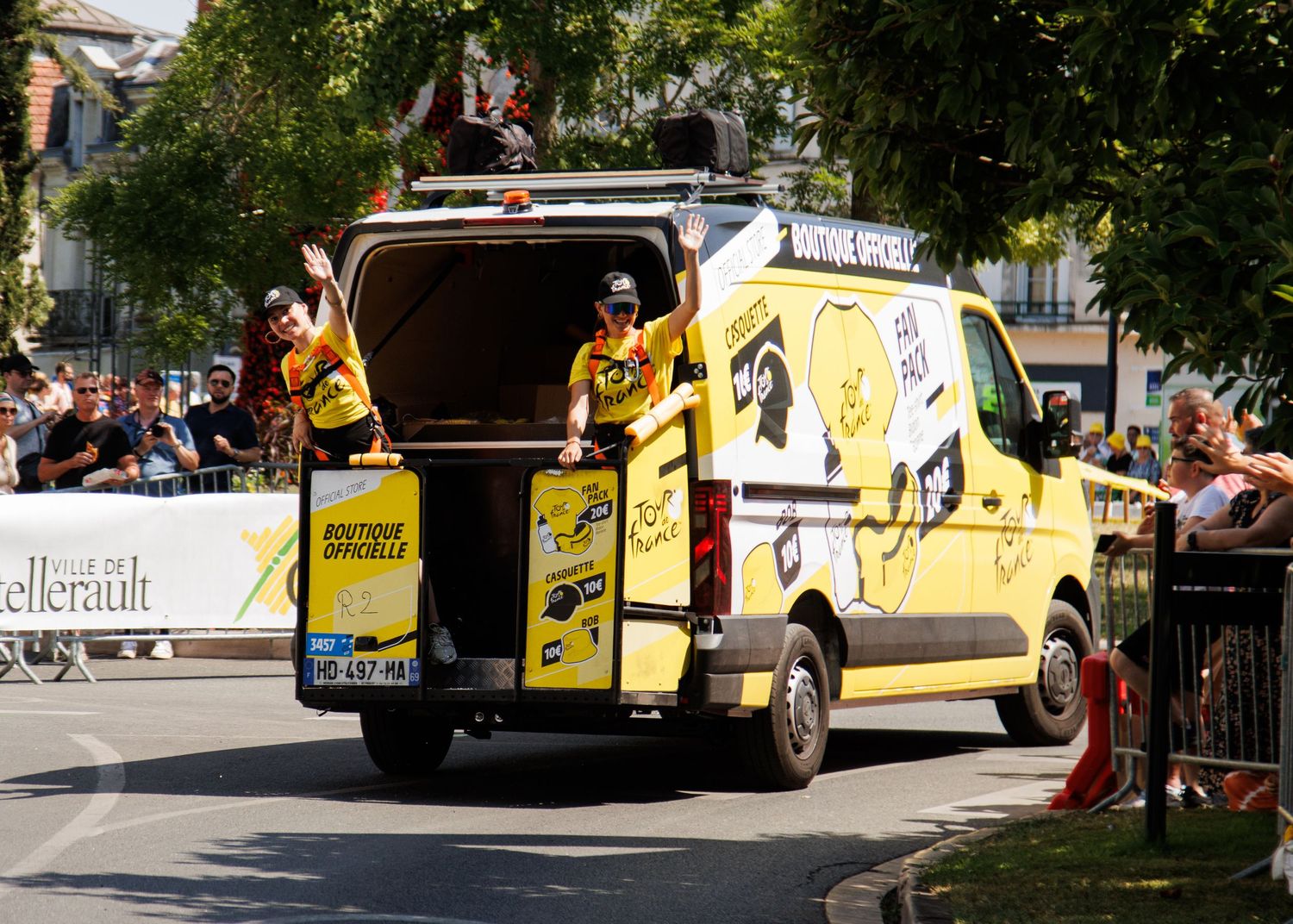 Support vehicle with open rear doors parked along race route.