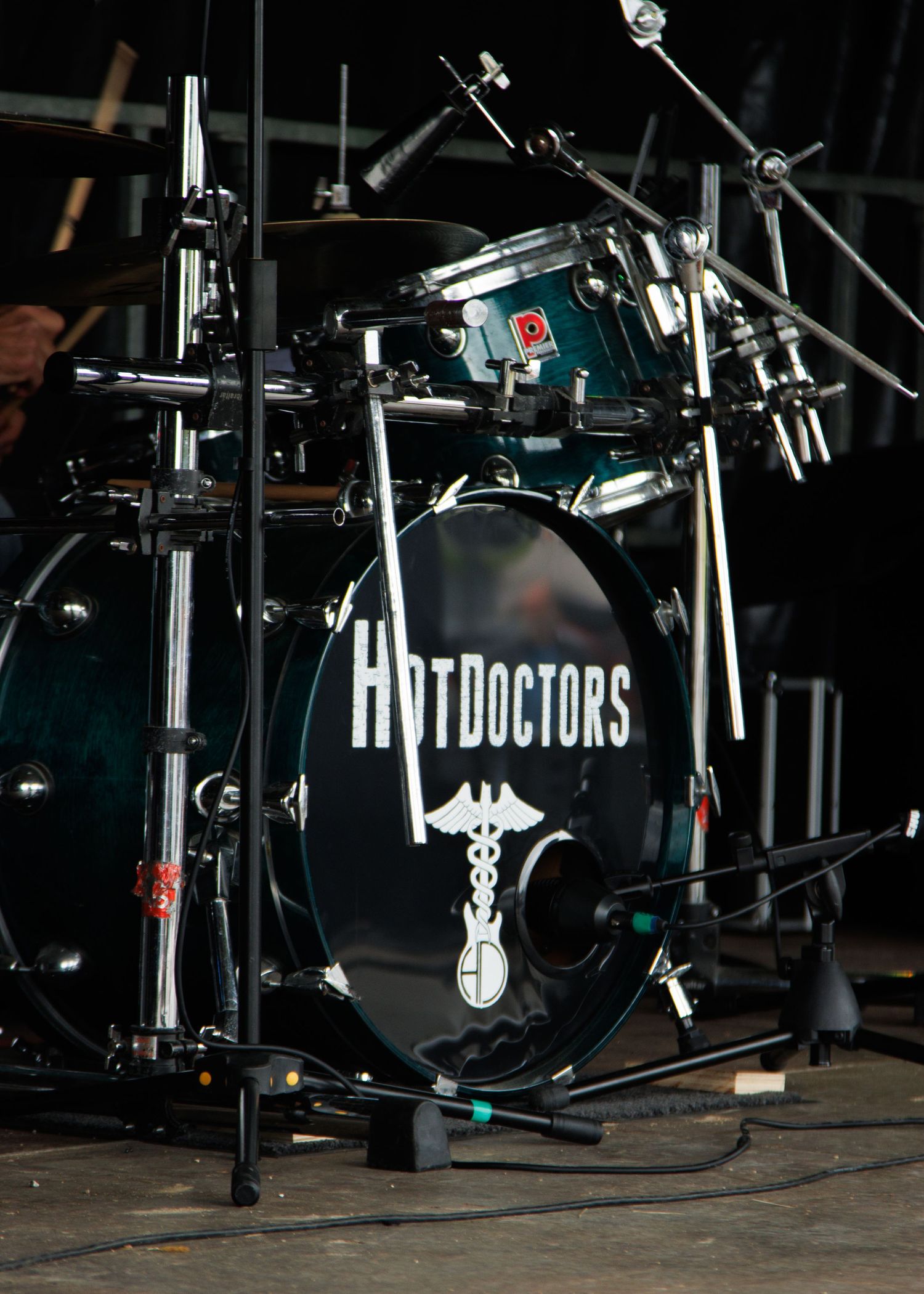Drum kit setup on stage with 'Hot Doctors' branding visible.