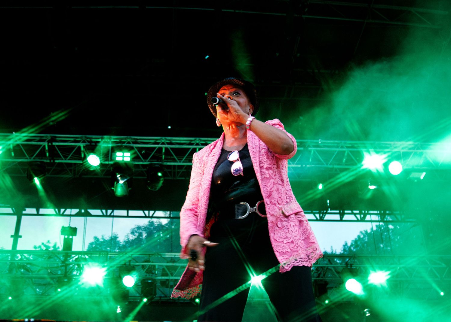 Performers on a concert stage illuminated by dramatic green lighting effects during a live show.