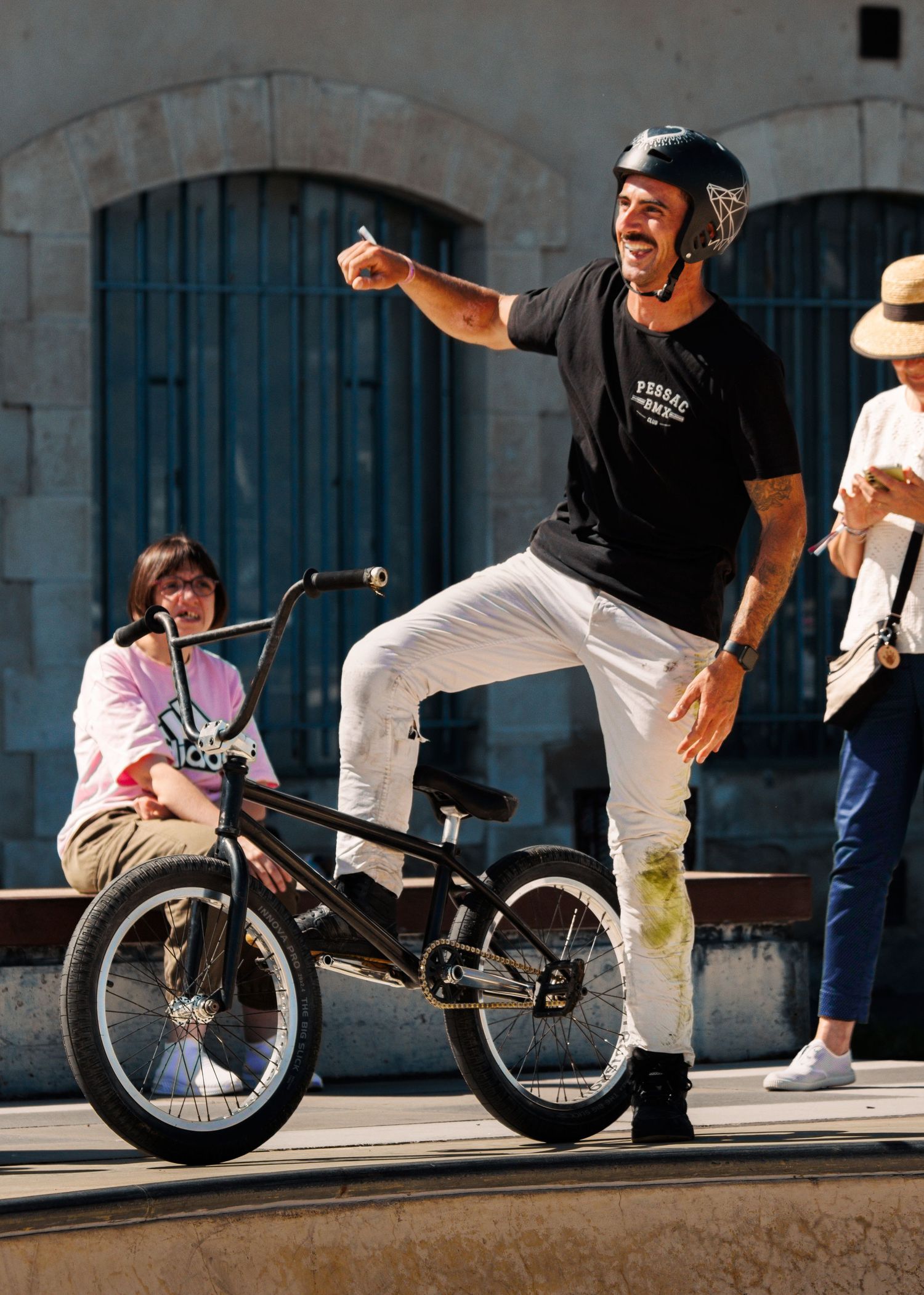 Sequence of BMX rider performing grind trick along stone wall ledge.
