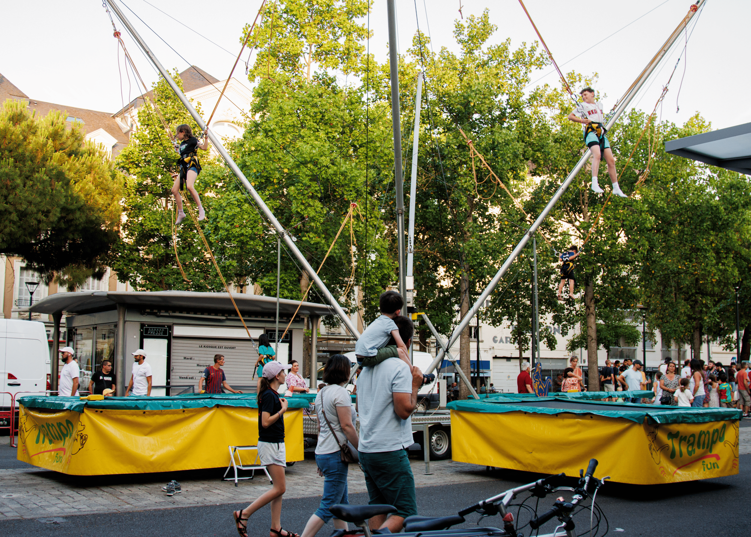 Festival grounds with yellow tents and carnival structures set up during daytime.