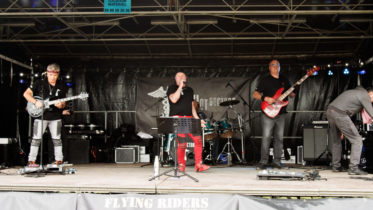 A rock band performing on an outdoor festival stage.