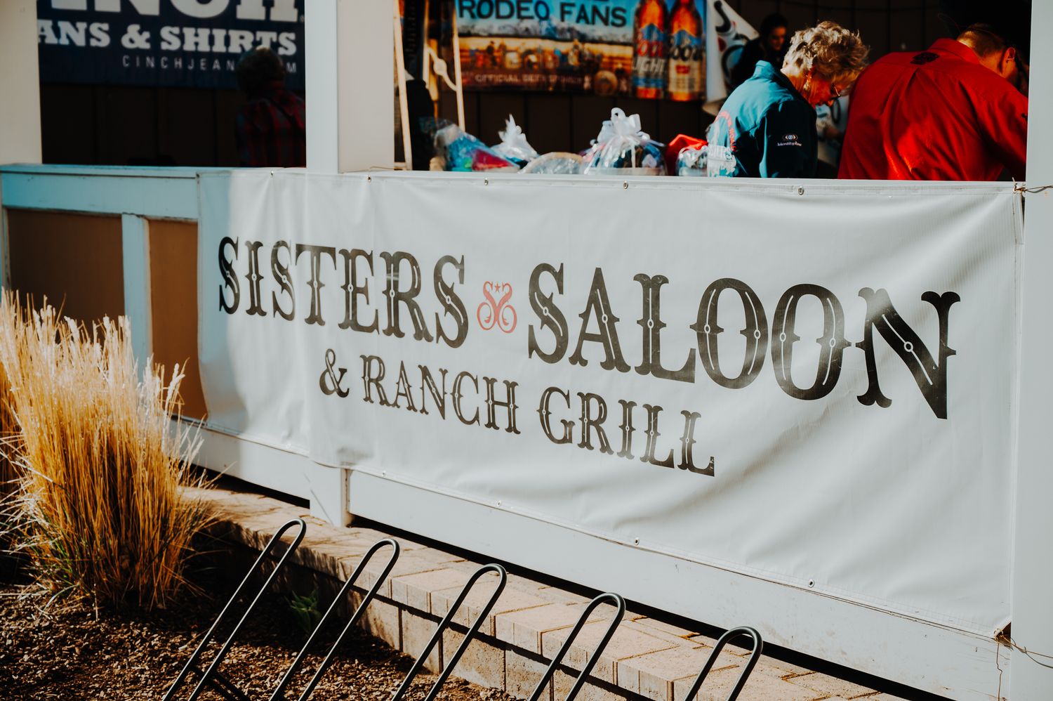 Banner for Sisters Saloon & Ranch Grill restaurant with rustic western decor.