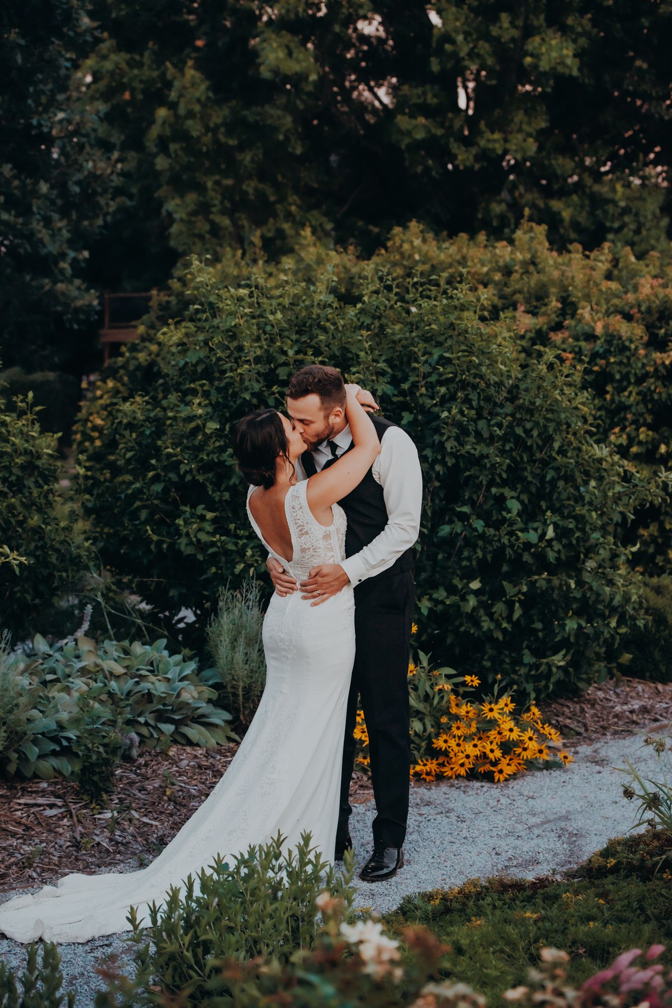 Romantic garden wedding moment captured among blooming flowers and greenery.